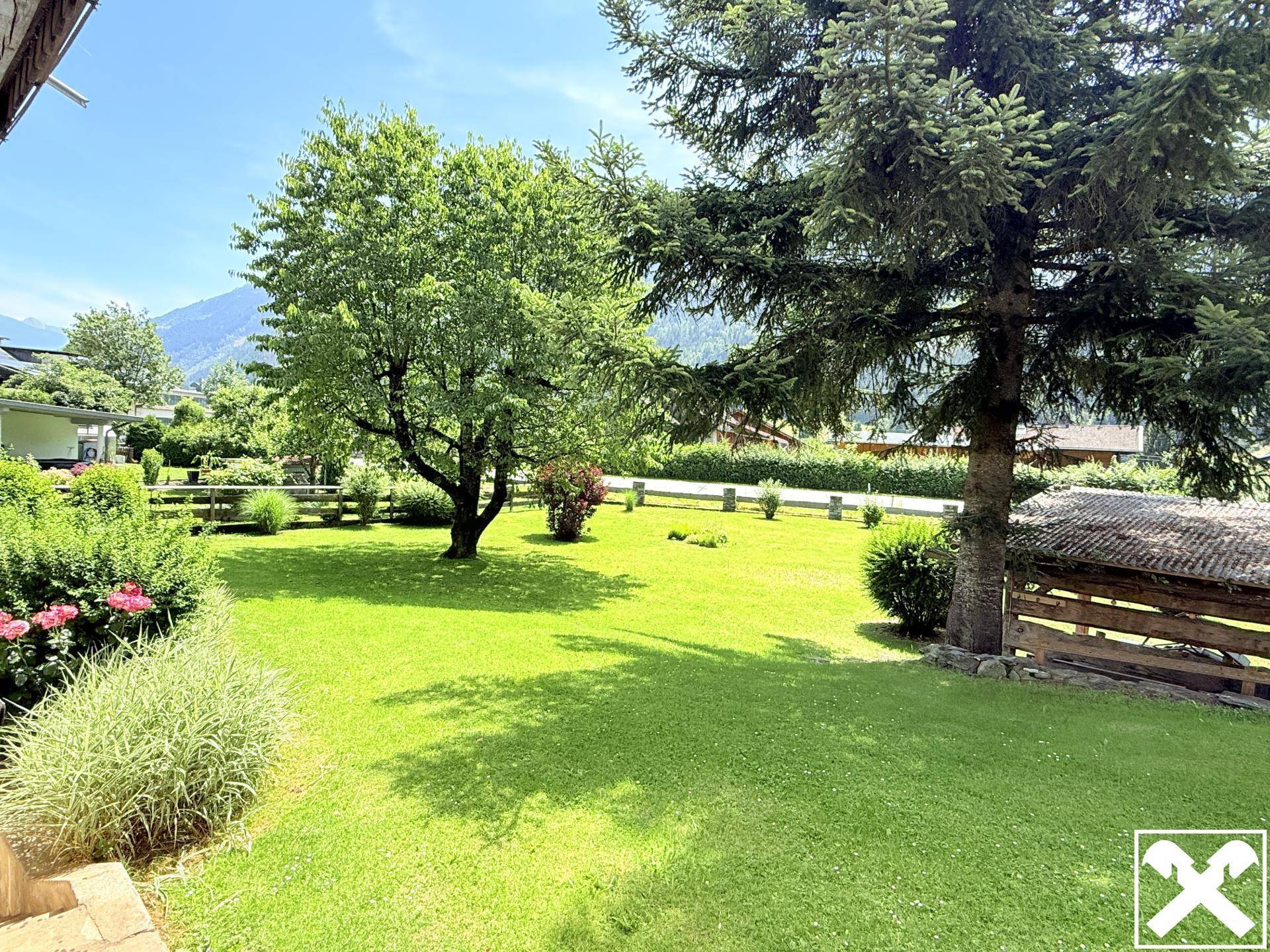Großer, gepflegter Garten mit altem Baumbestand und weitem Blick auf die umliegenden Berge.