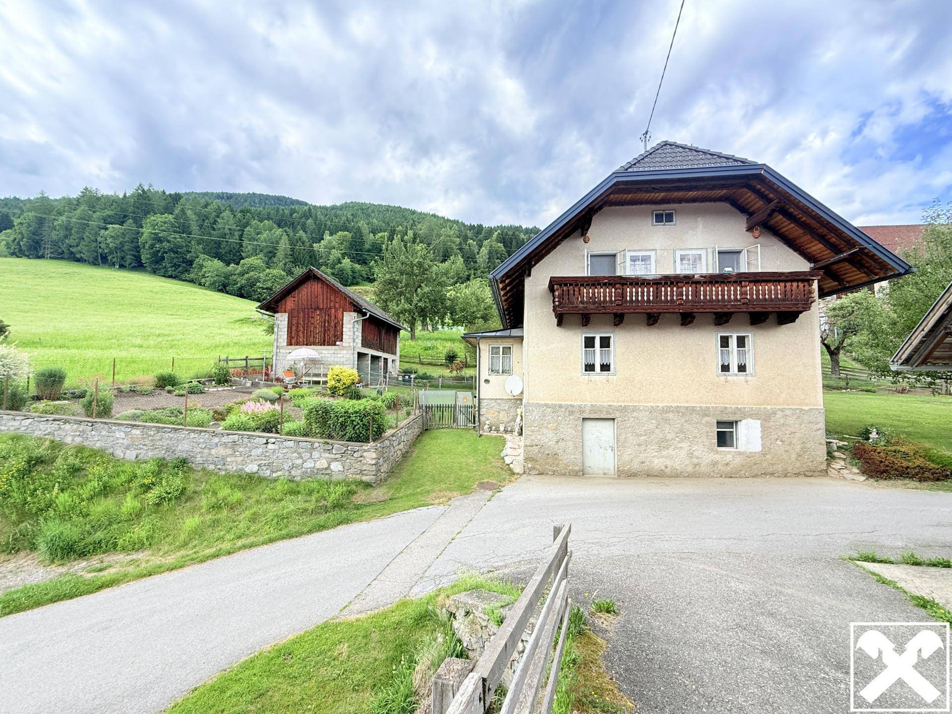Haus außen mit Nebengebäude und Gemüsegarten