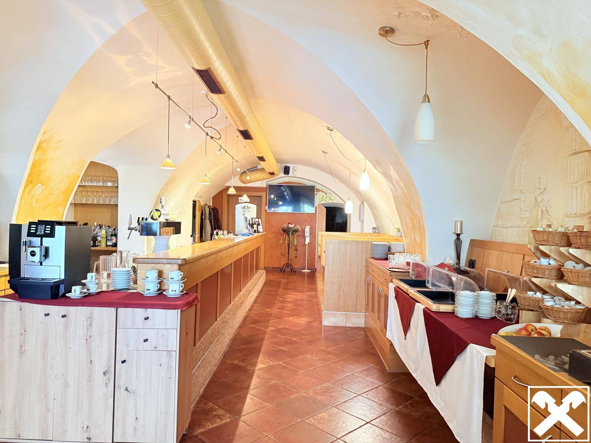 Geräumiger Speisesaal mit gewölbter Decke, Terrakotta-Fliesenboden und Buffetbereich.