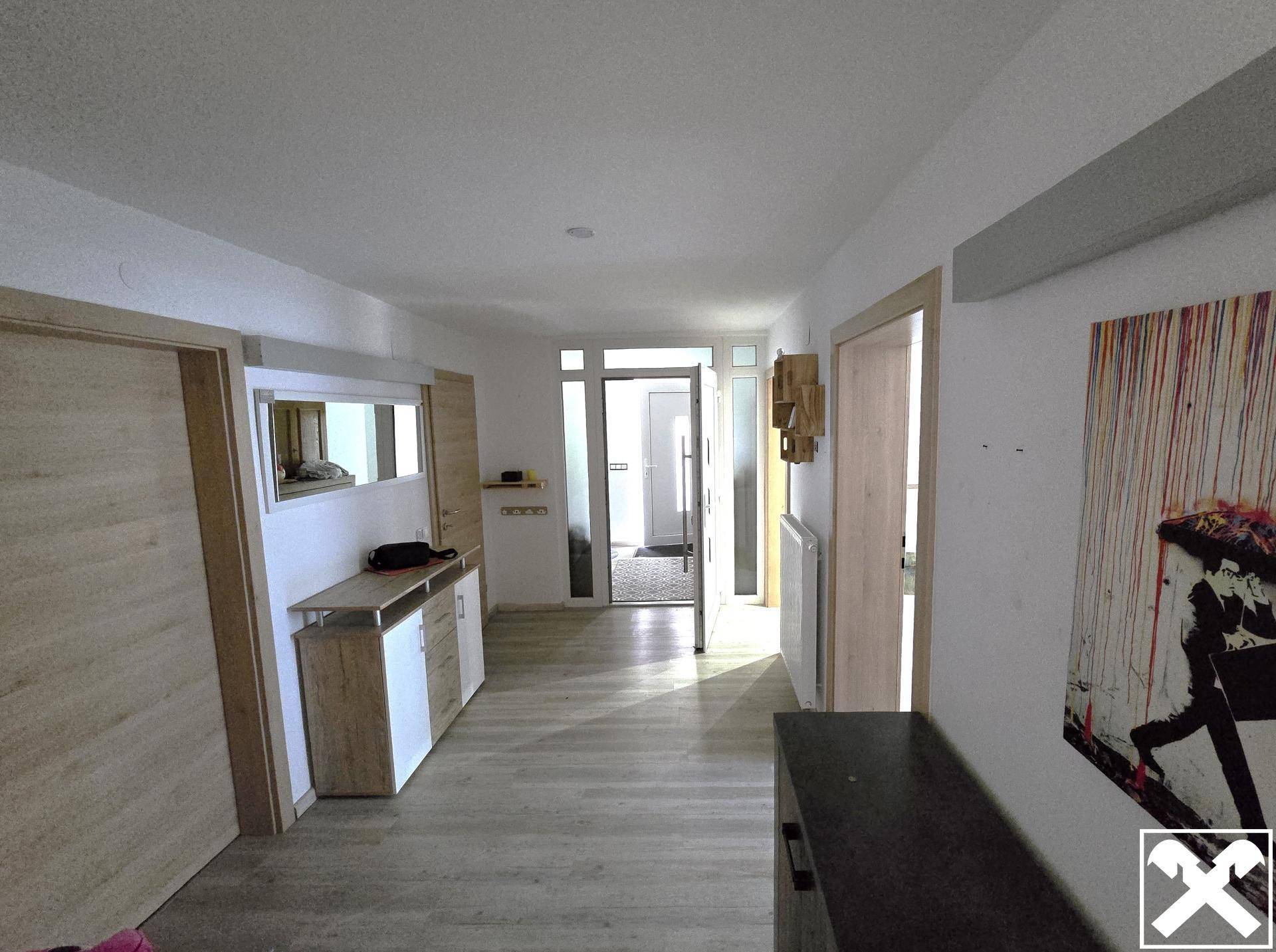 Langer Flur mit Holztüren, einer Konsole und einem großen Spiegel.