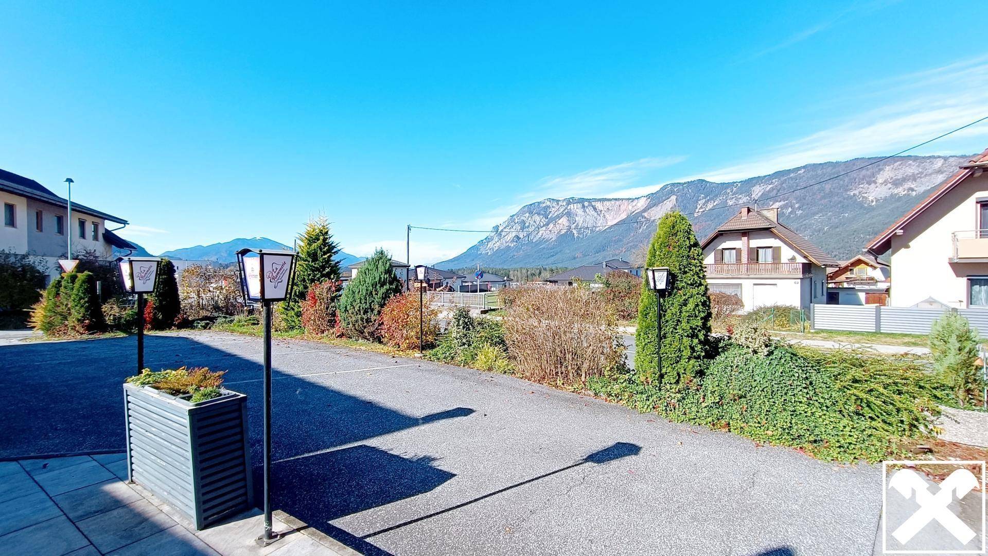 Weitläufiger Außenbereich mit Parkmöglichkeiten und einem beeindruckenden Panoramablick auf die umliegende Berglandschaft.