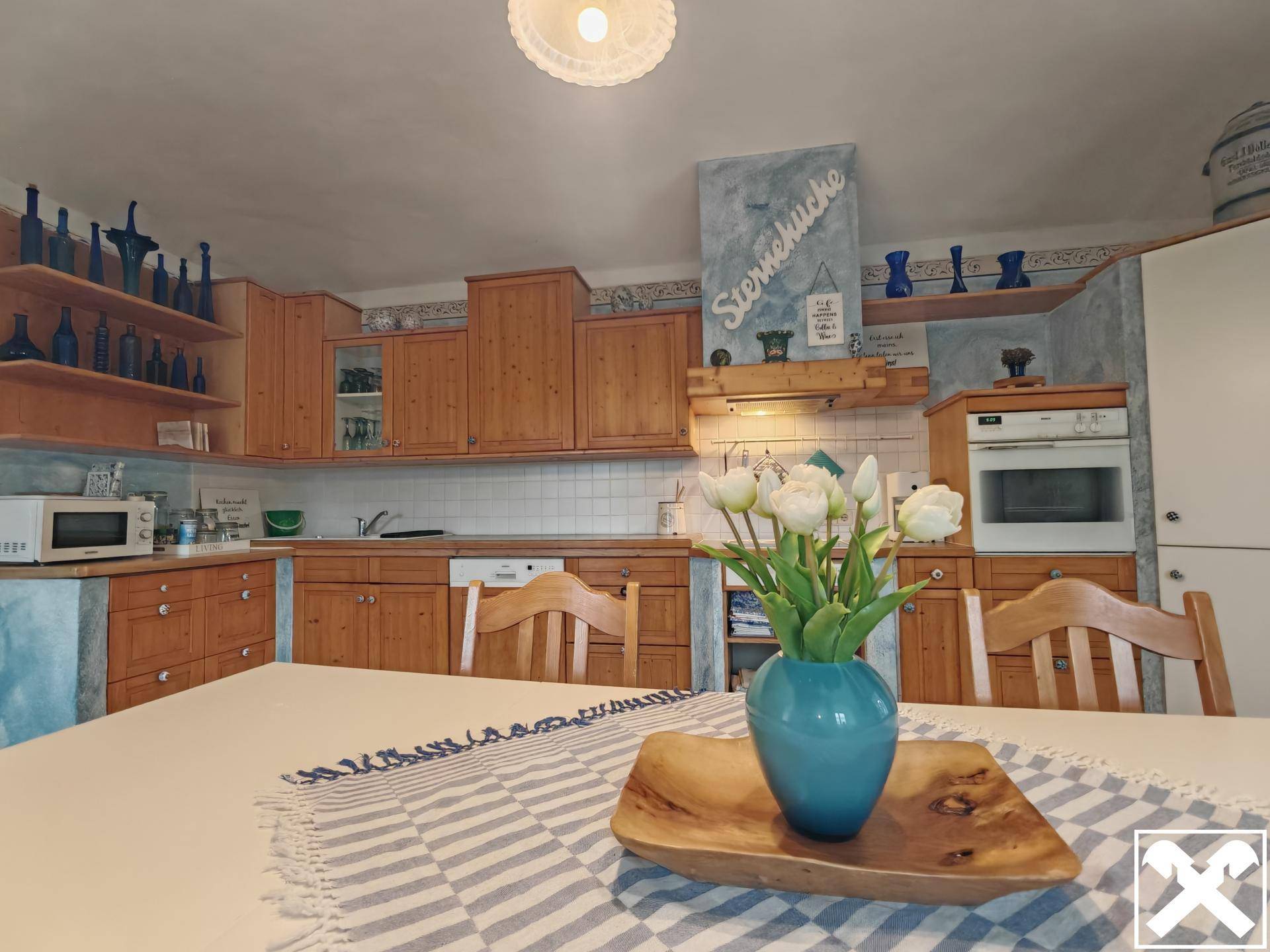 Detailansicht der traditionellen Wohnküche mit Holzelementen und modernen Geräten.