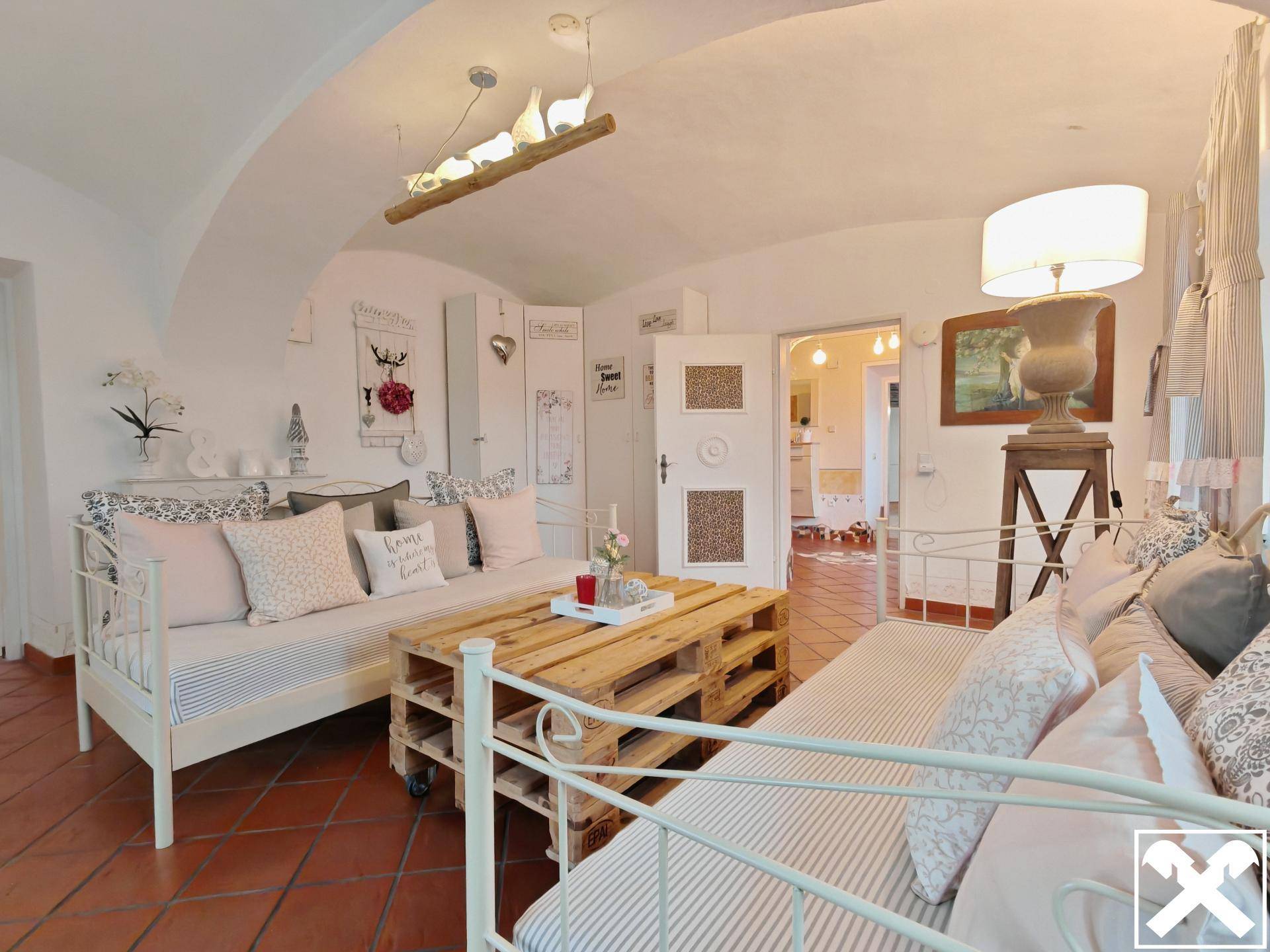 Gemütlicher Wohnbereich mit gewölbter Decke, Terrakotta-Fliesen und rustikalen Möbeln.