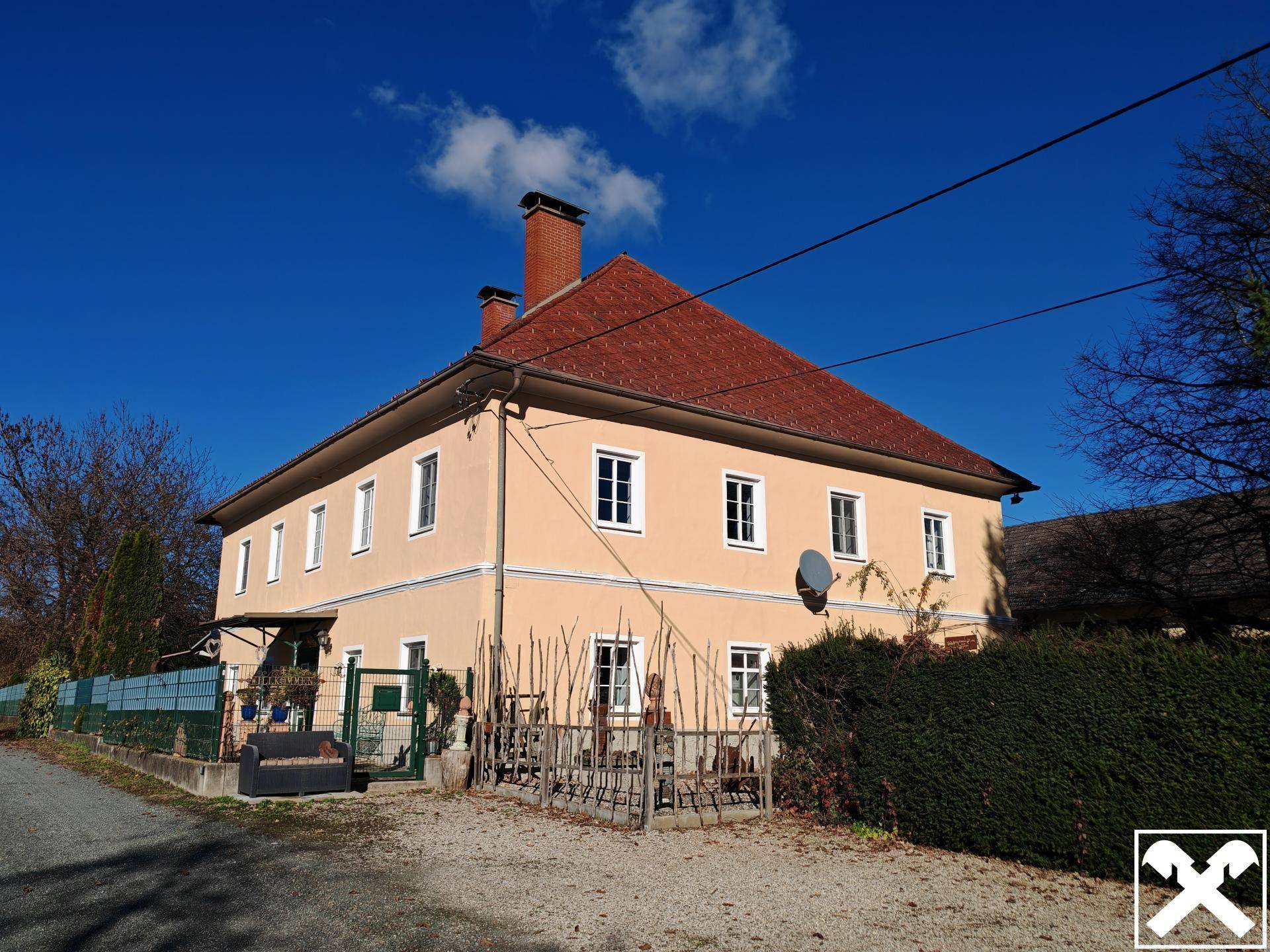 Seitenansicht eines traditionellen Gebäudes mit rotem Ziegeldach und gepflegter Fassade.