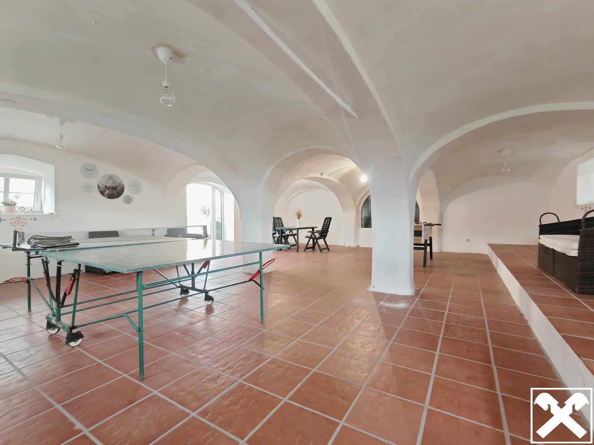 Großer Gewölberaum im Untergeschoss, genutzt als Freizeitbereich mit Tischtennisplatte.