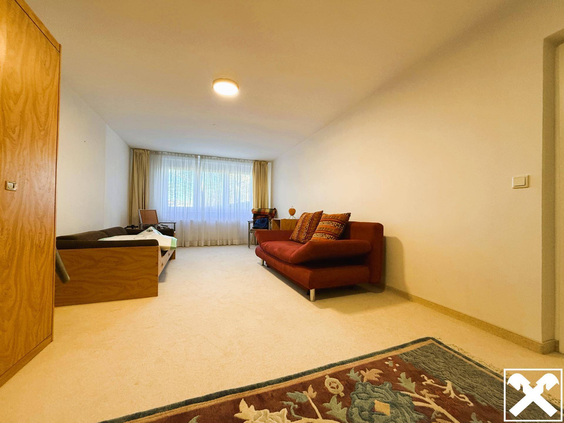 Geräumiger Mehrzweckraum mit Sofa, Tagesbett und großen Fenstern.