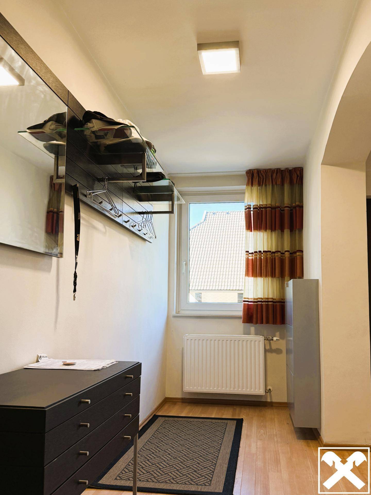 Freundlicher Flur mit Fenster, Heizkörper und praktischer Garderobe für den Eingangsbereich.