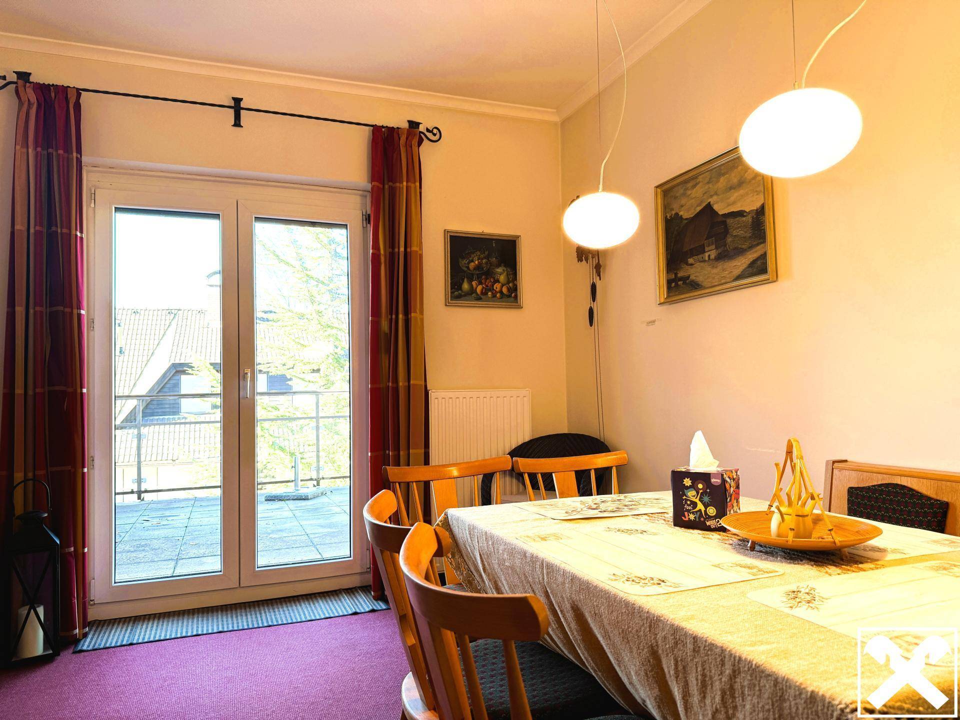 Esszimmer mit Holztisch, Stühlen und Zugang zu einer großen Terrasse.