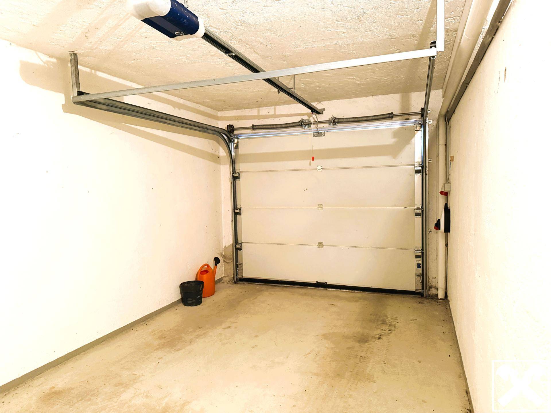 Geräumige Einzelgarage mit automatischem Tor und ausreichend Platz für ein Fahrzeug.
