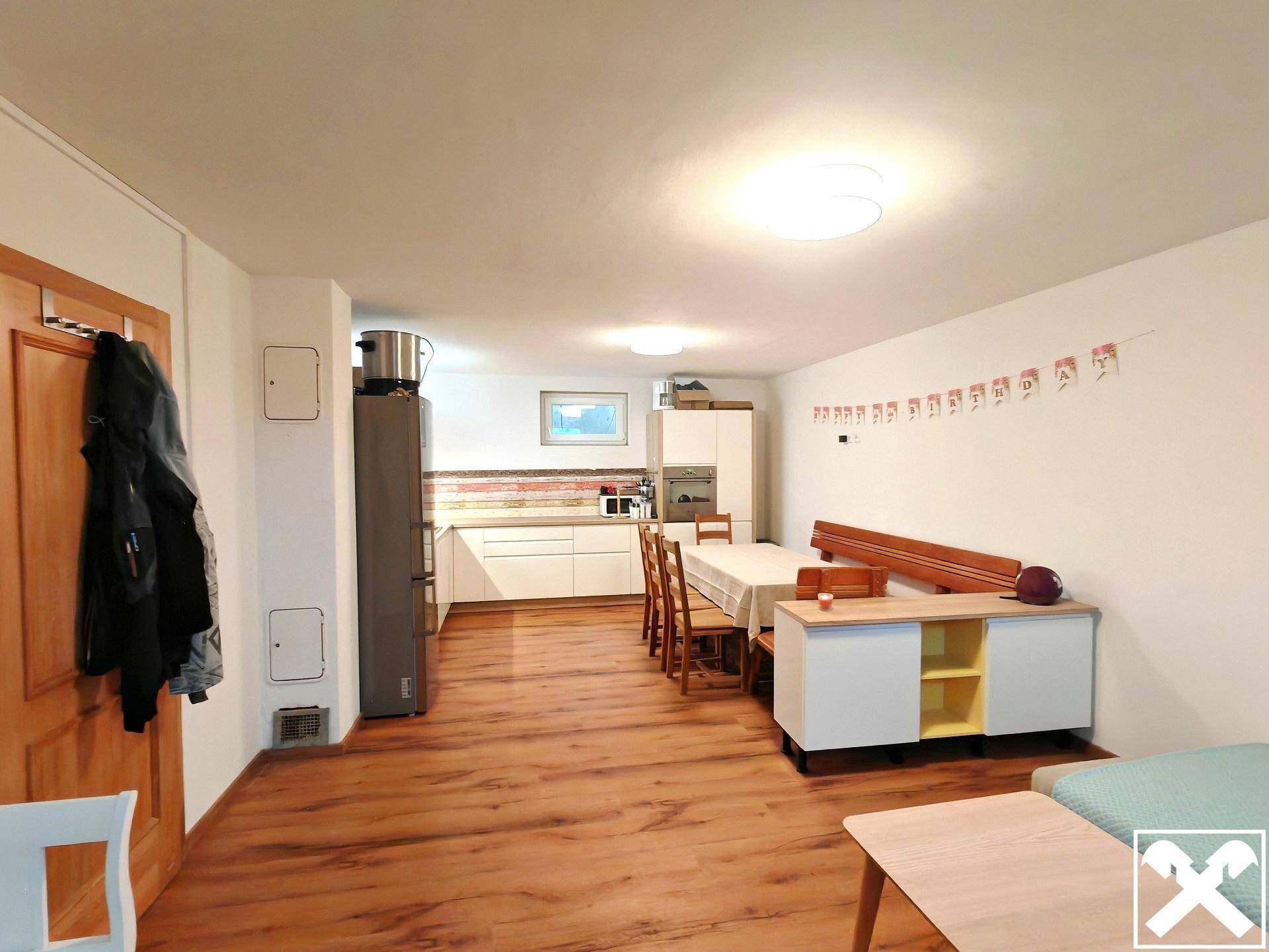 Heller Wohn-Essbereich mit integrierter Küche, Holzfußboden und moderner Einrichtung.