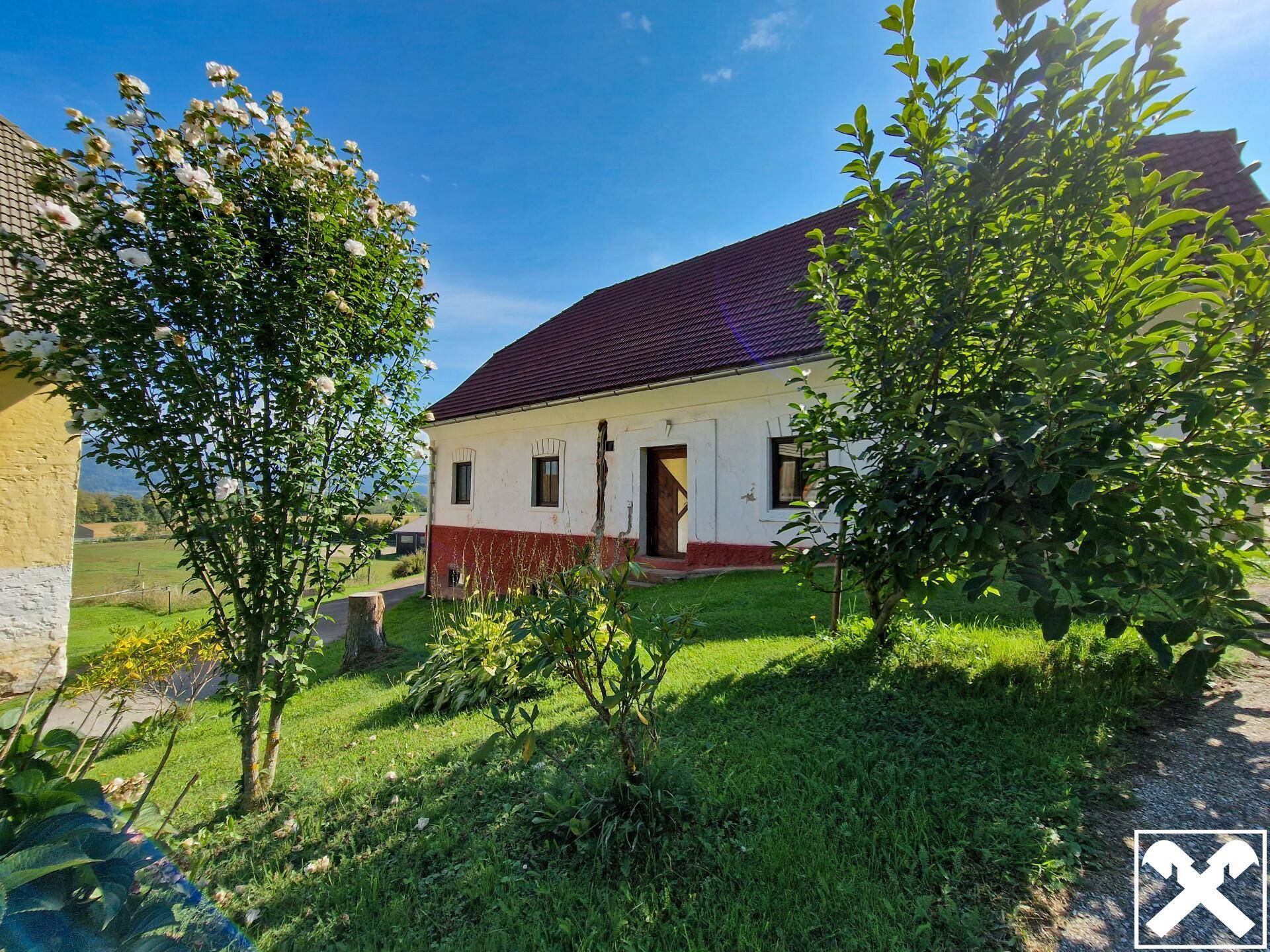 Traditionelles Landhaus mit blühenden Bäumen und gepflegtem Gartenbereich.