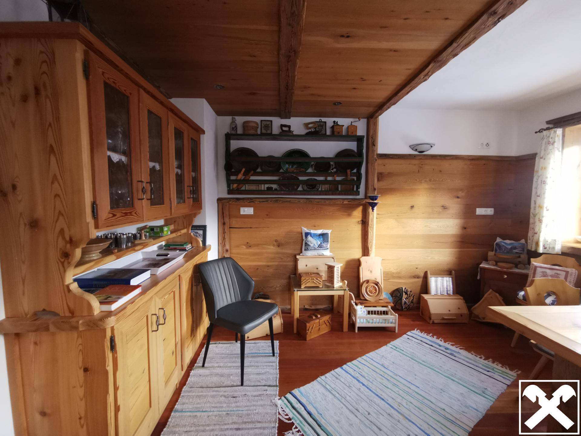 Rustikaler Wohnbereich mit Holzböden, Holzvertäfelung und traditionellen Möbeln, strahlt Gemütlichkeit aus.