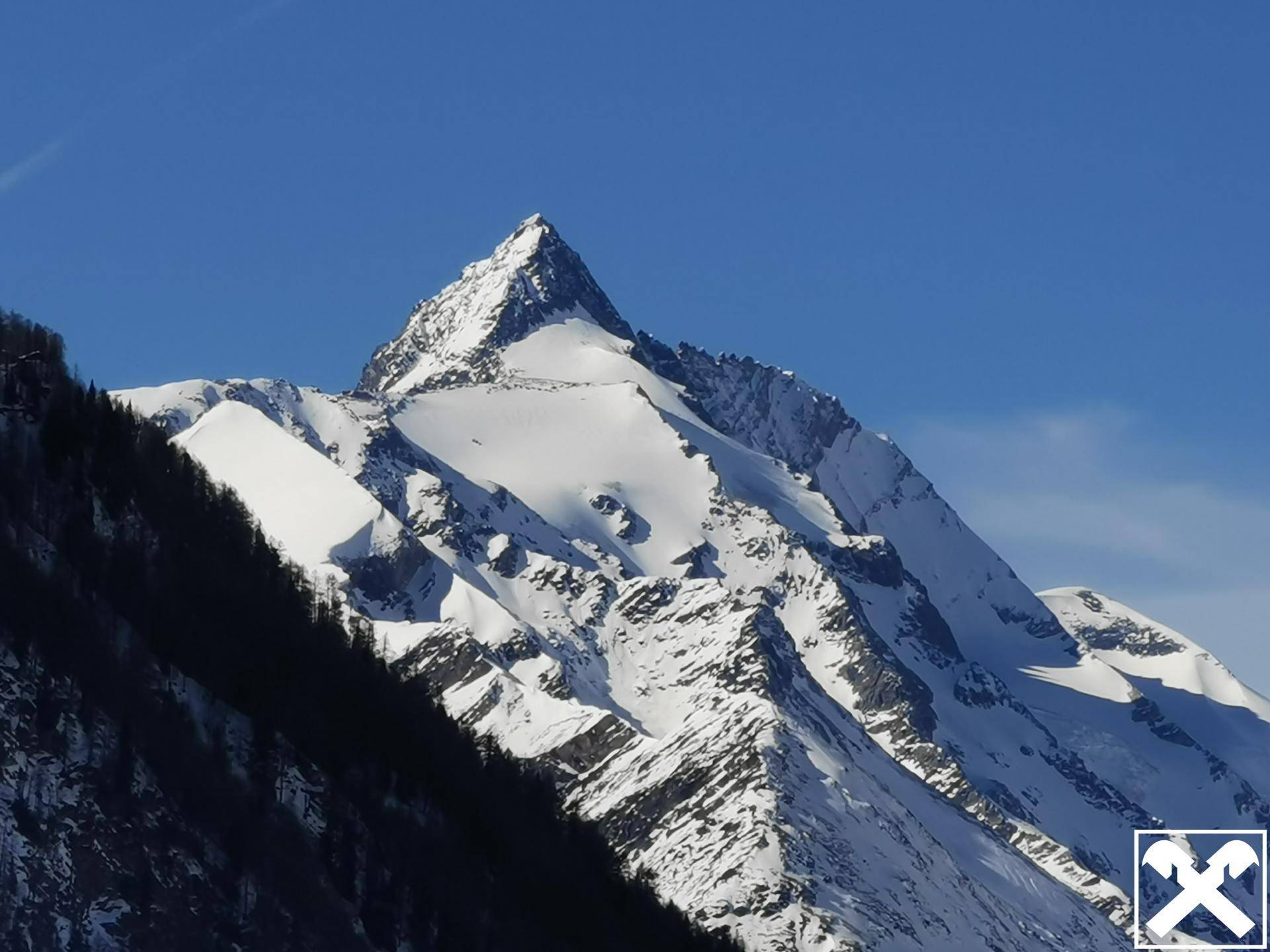 Majestätischer, schneebedeckter Berggipfel unter strahlend blauem Himmel, der eine beeindruckende Naturkulisse bietet.