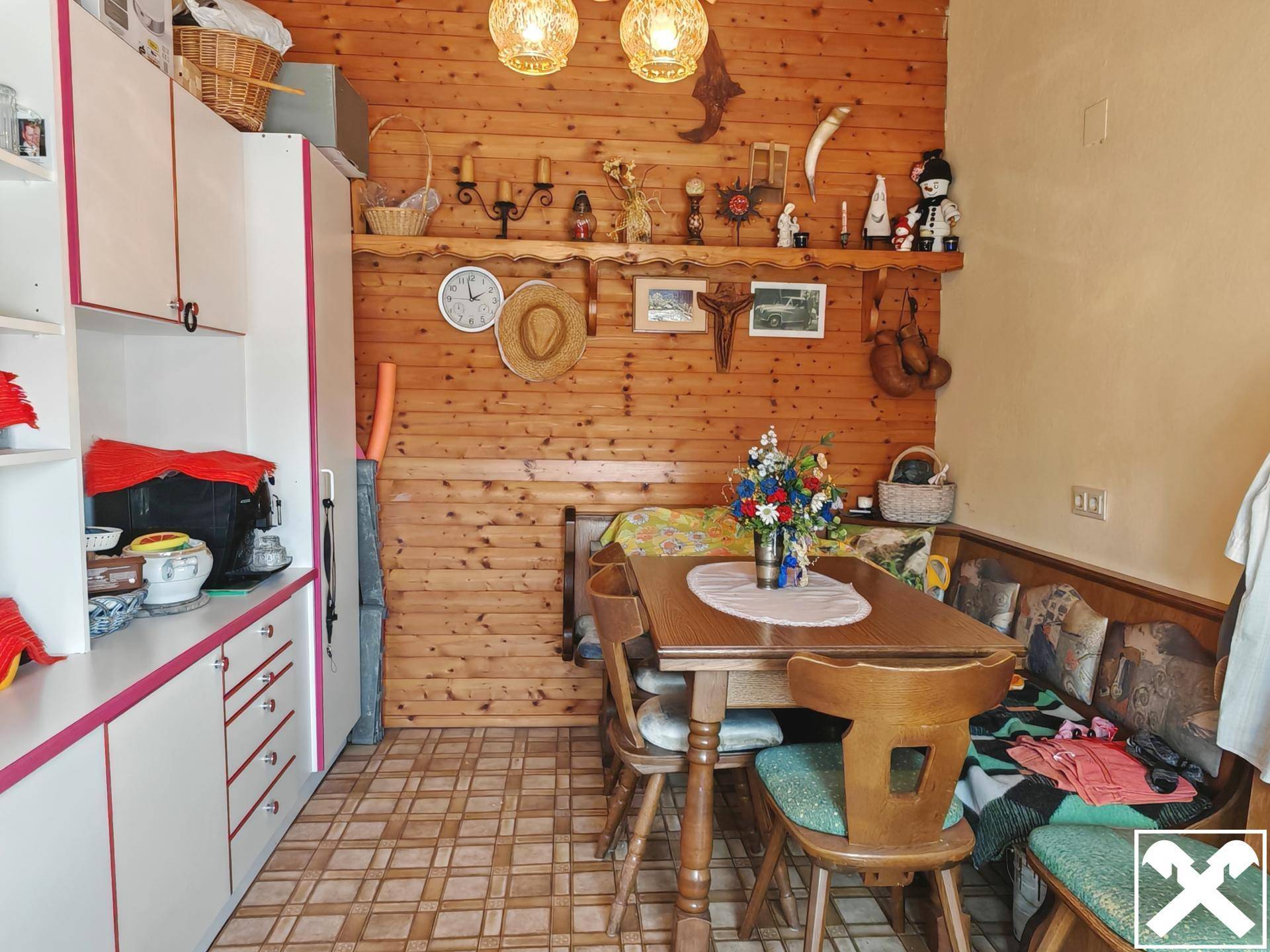 Gemütlicher Essbereich mit Holzvertäfelung, Eckbank und traditioneller Dekoration.