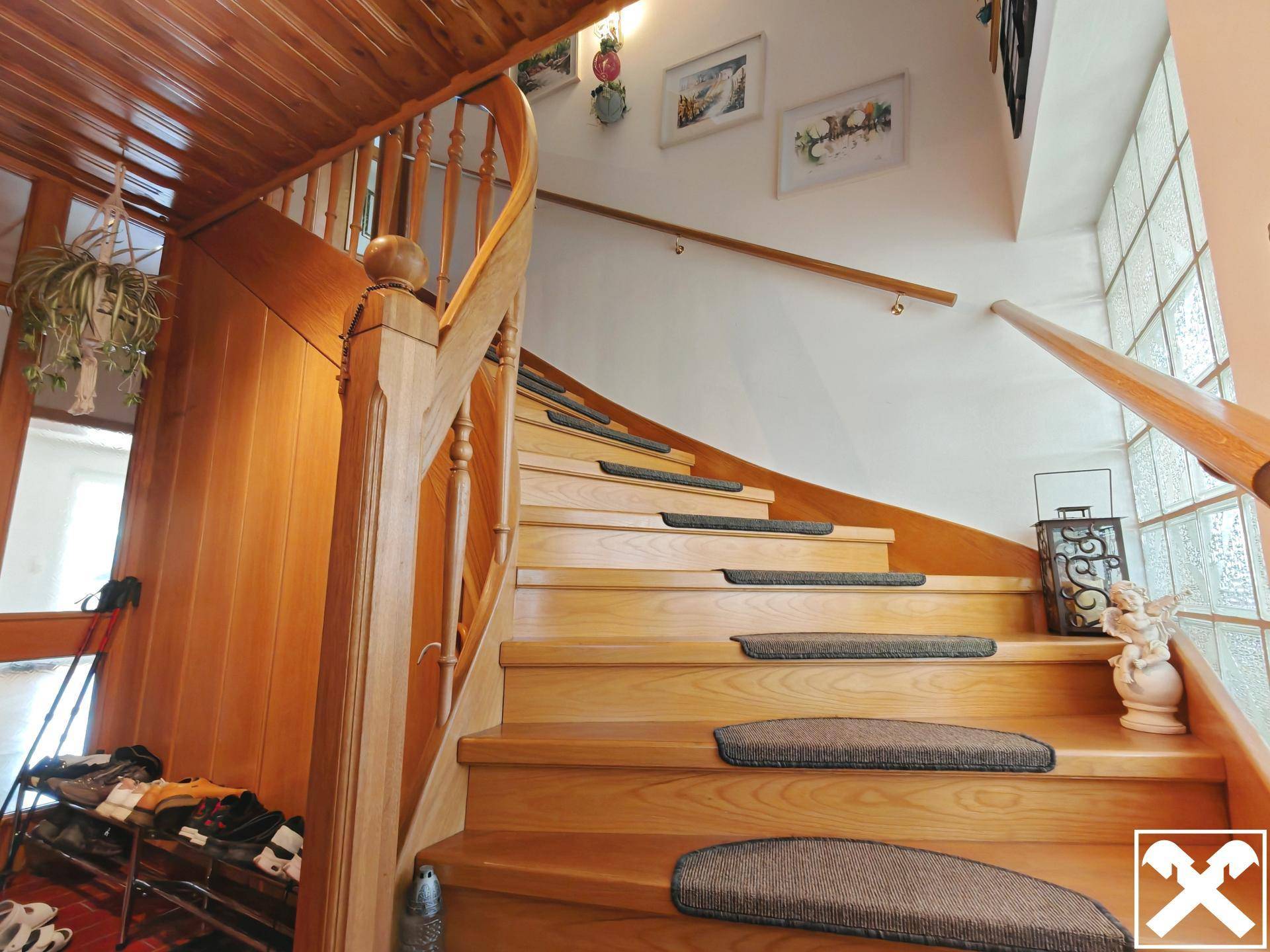 Elegante Holztreppe mit geschwungenem Geländer und Teppichläufern.