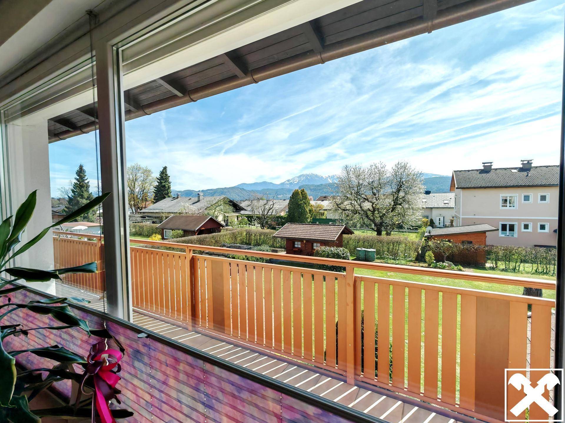Panoramablick aus dem Fenster auf die umliegende Berglandschaft und den Garten.