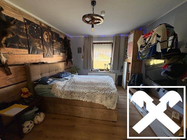 Rustikales Schlafzimmer mit Holzwand, Doppelbett und individueller Dekoration.