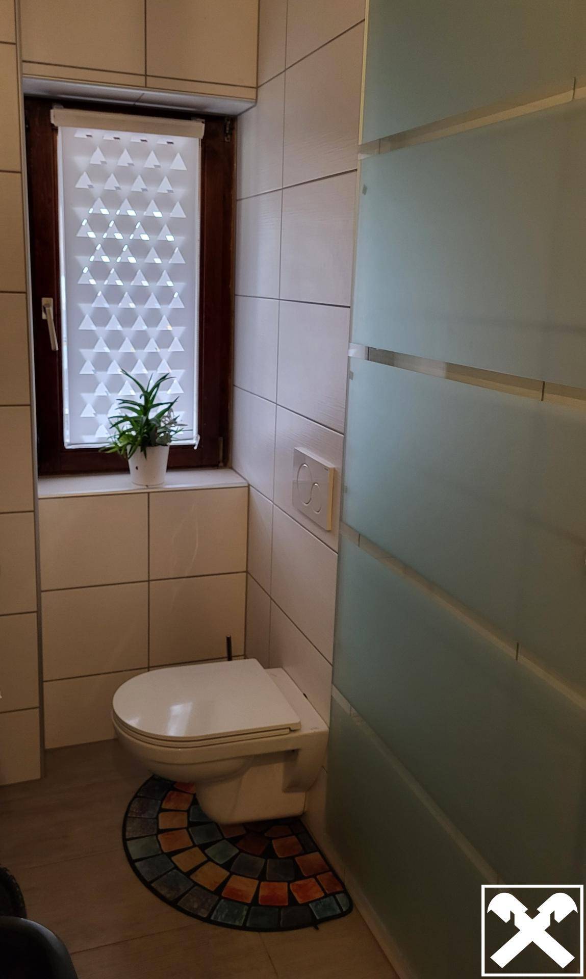 Modernes Gäste-WC mit Wand-WC, weißen Fliesen und Fenster für Tageslicht.