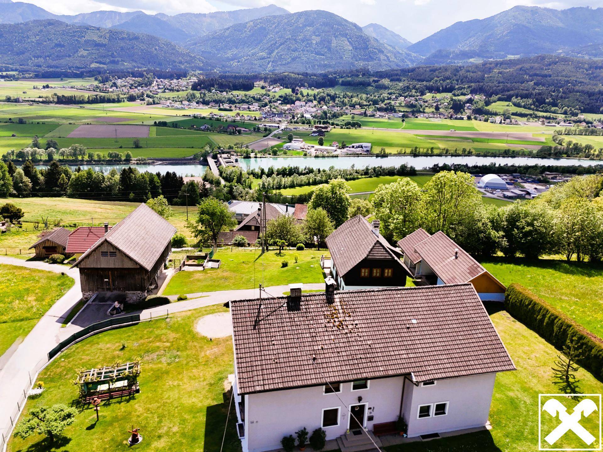 Weitläufige Luftaufnahme des Anwesens mit Fluss im Hintergrund und umliegender Natur.