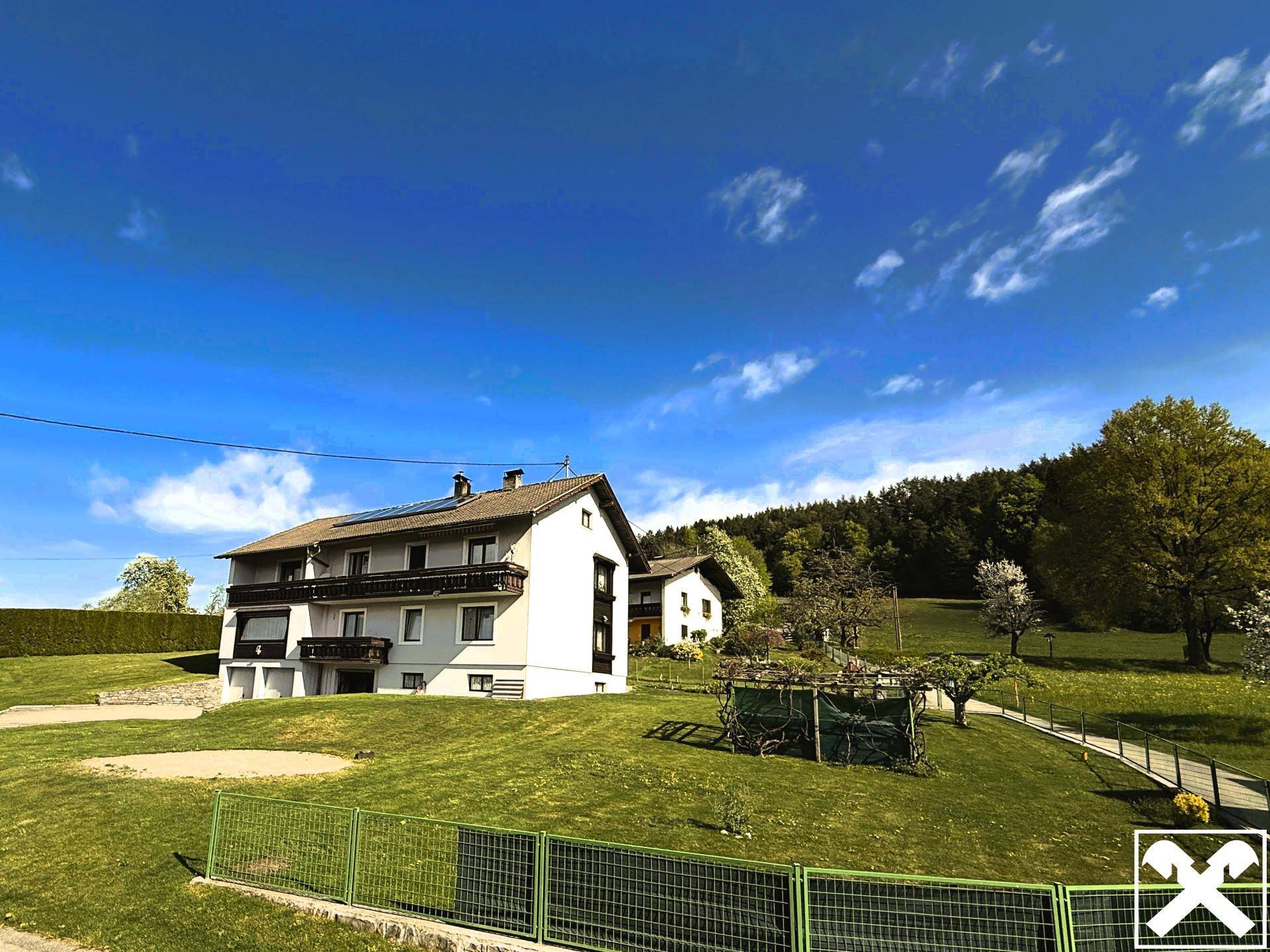 Wohnhaus in ländlicher Umgebung mit großem Garten und Blick auf die umliegende Natur.