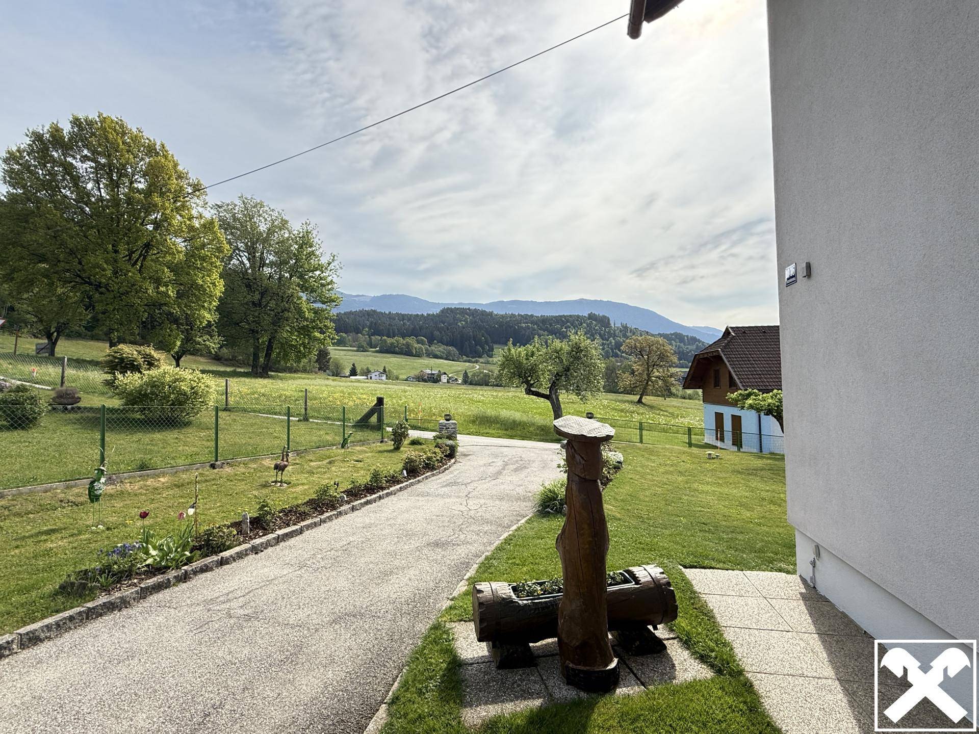 Panoramablick vom Grundstück über die weite grüne Landschaft und die fernen Berge.
