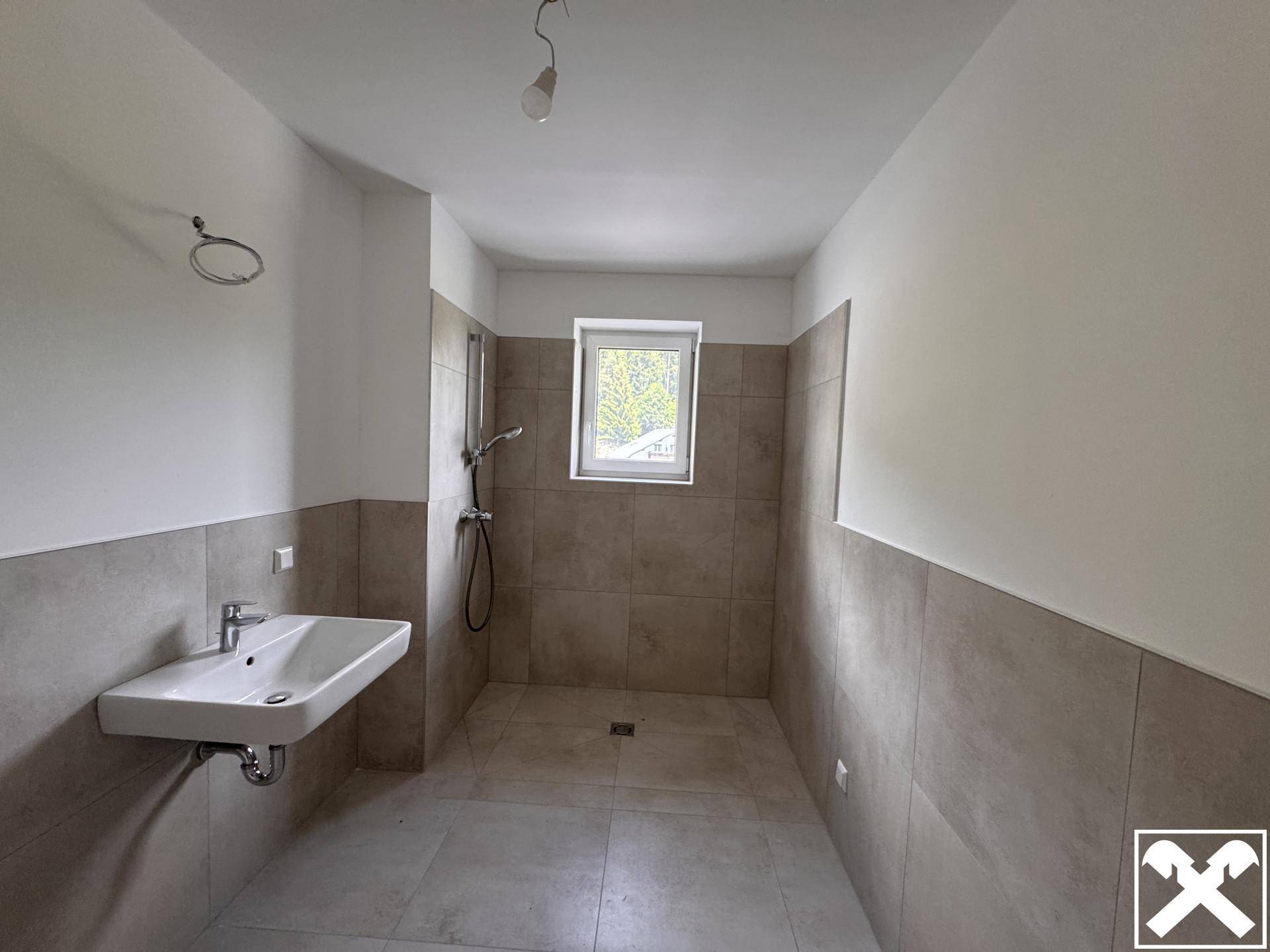 Modernes Badezimmer mit ebenerdiger Dusche, Einzelwaschbecken und einem Fenster für Tageslicht.