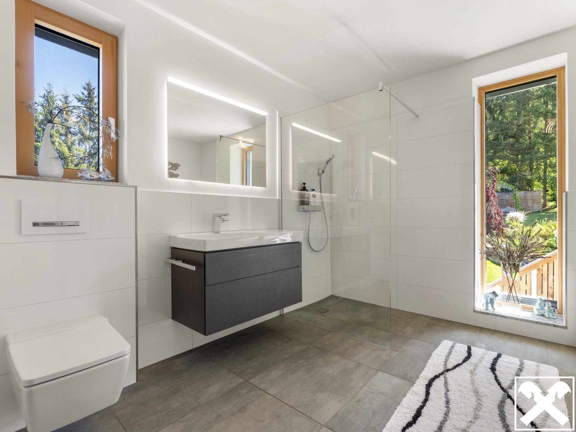 Modernes Badezimmer mit begehbarer Dusche, schwebendem Waschtisch und großen Fenstern.