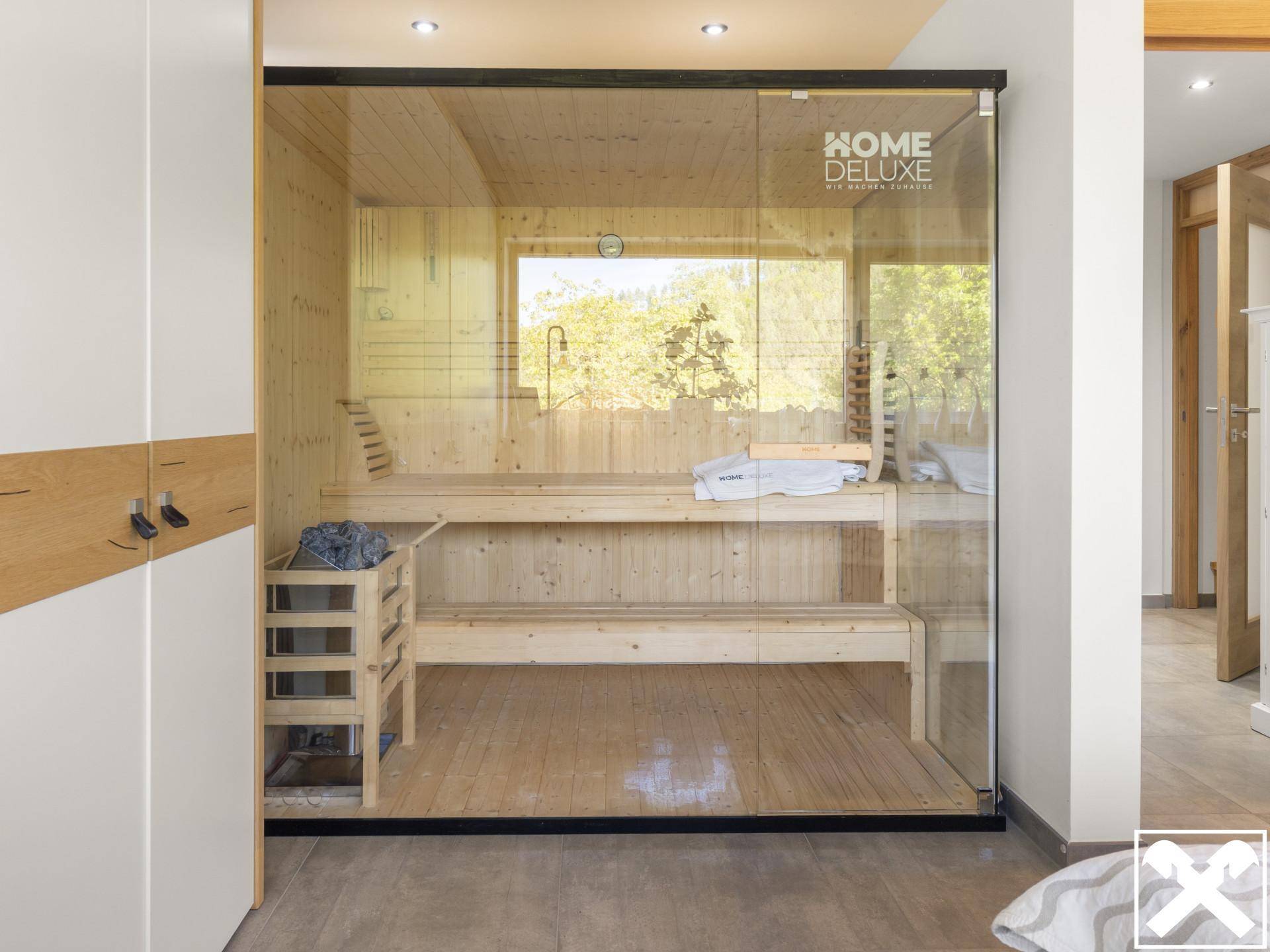 Moderne Sauna mit Holzbänken und Glasfront, die zum Entspannen einlädt.