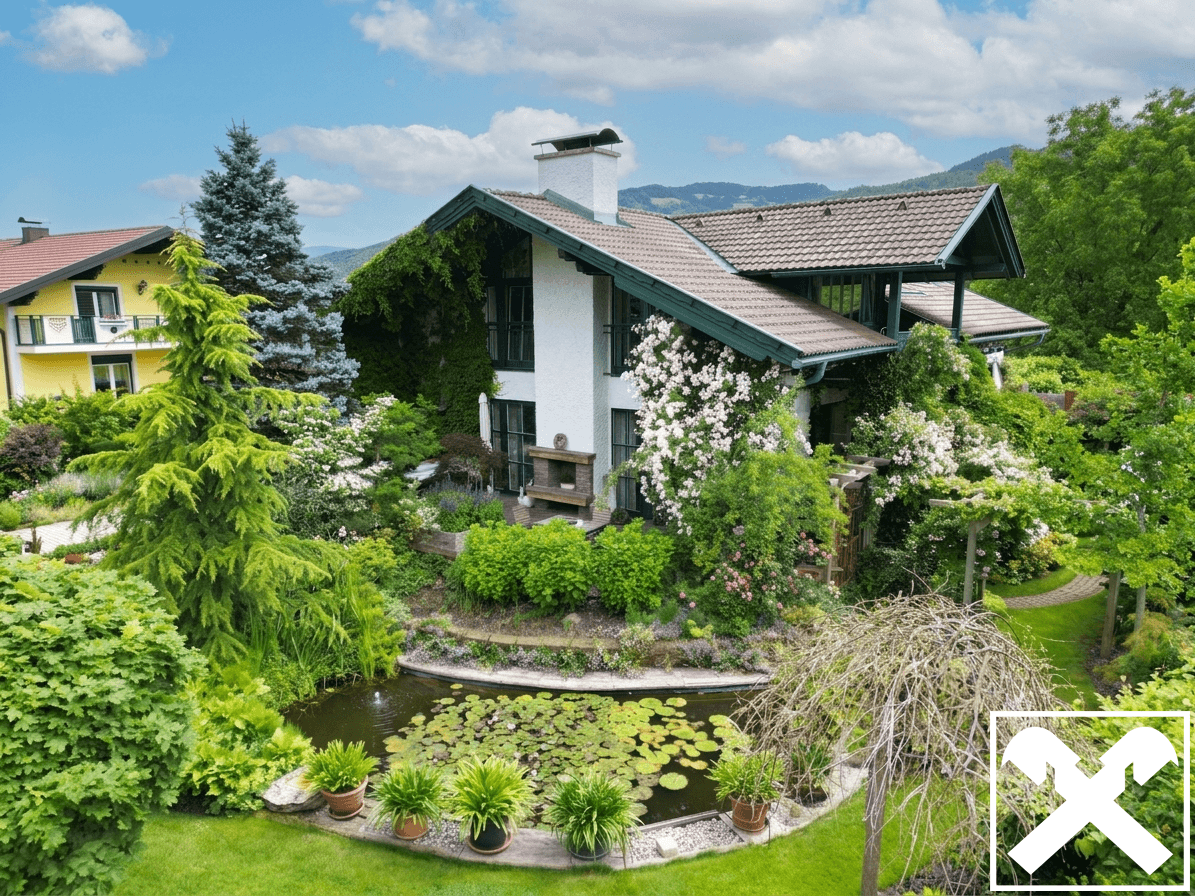 Das Haus umgeben von einem üppigen Garten mit einem dekorativen Teich und blühenden Pflanzen.