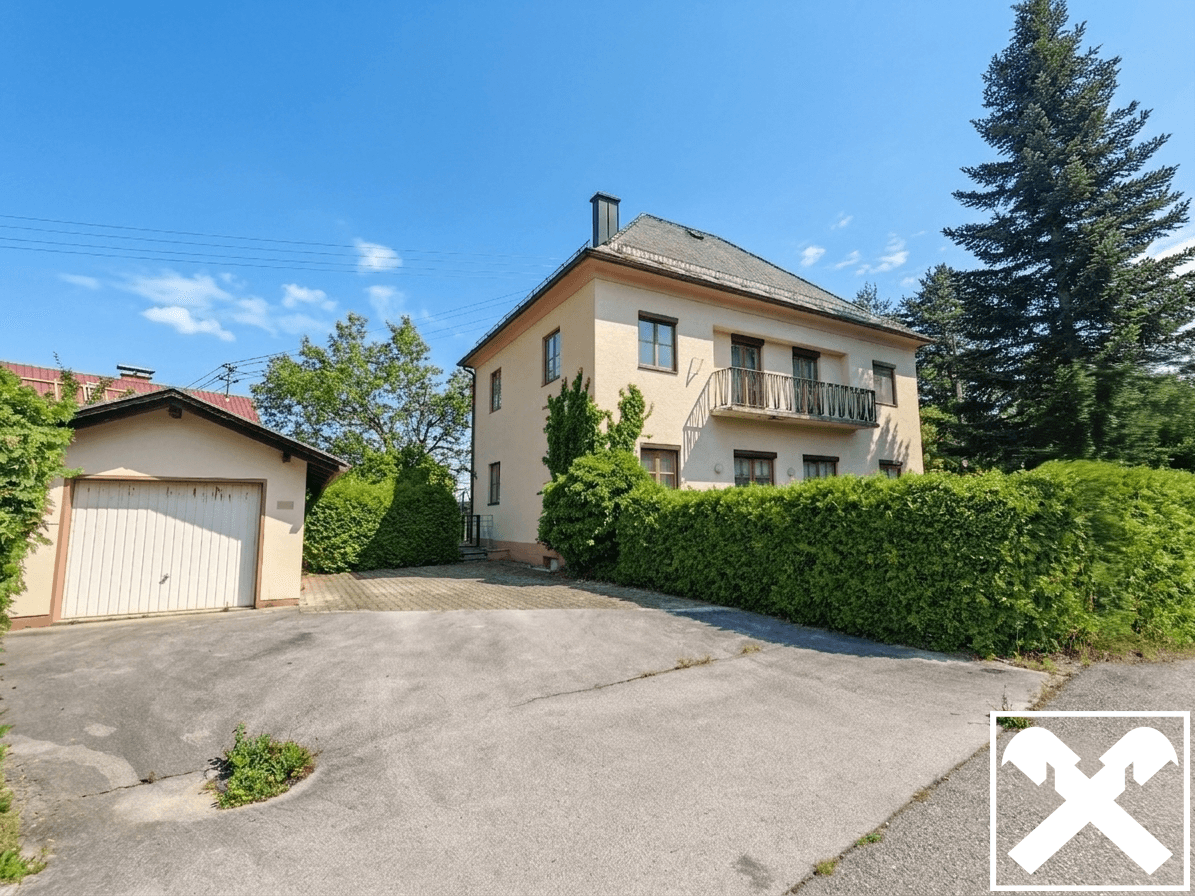 Ansicht des Hauses von der Einfahrt mit separater Garage und gepflegter Hecke.