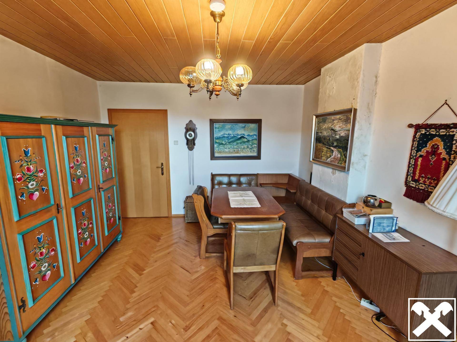 Esszimmer mit Holzdecke, Parkettboden und traditionellen Möbeln, inklusive Eckbank.