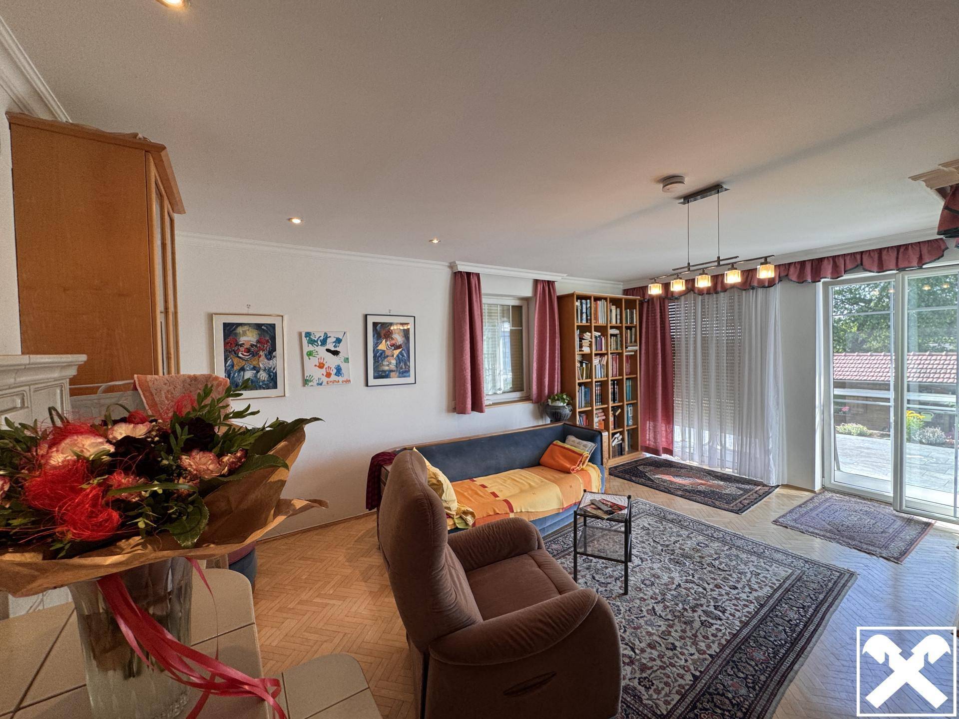 Geräumiges Wohnzimmer mit Parkettboden, bequemen Möbeln und Zugang zur Terrasse.