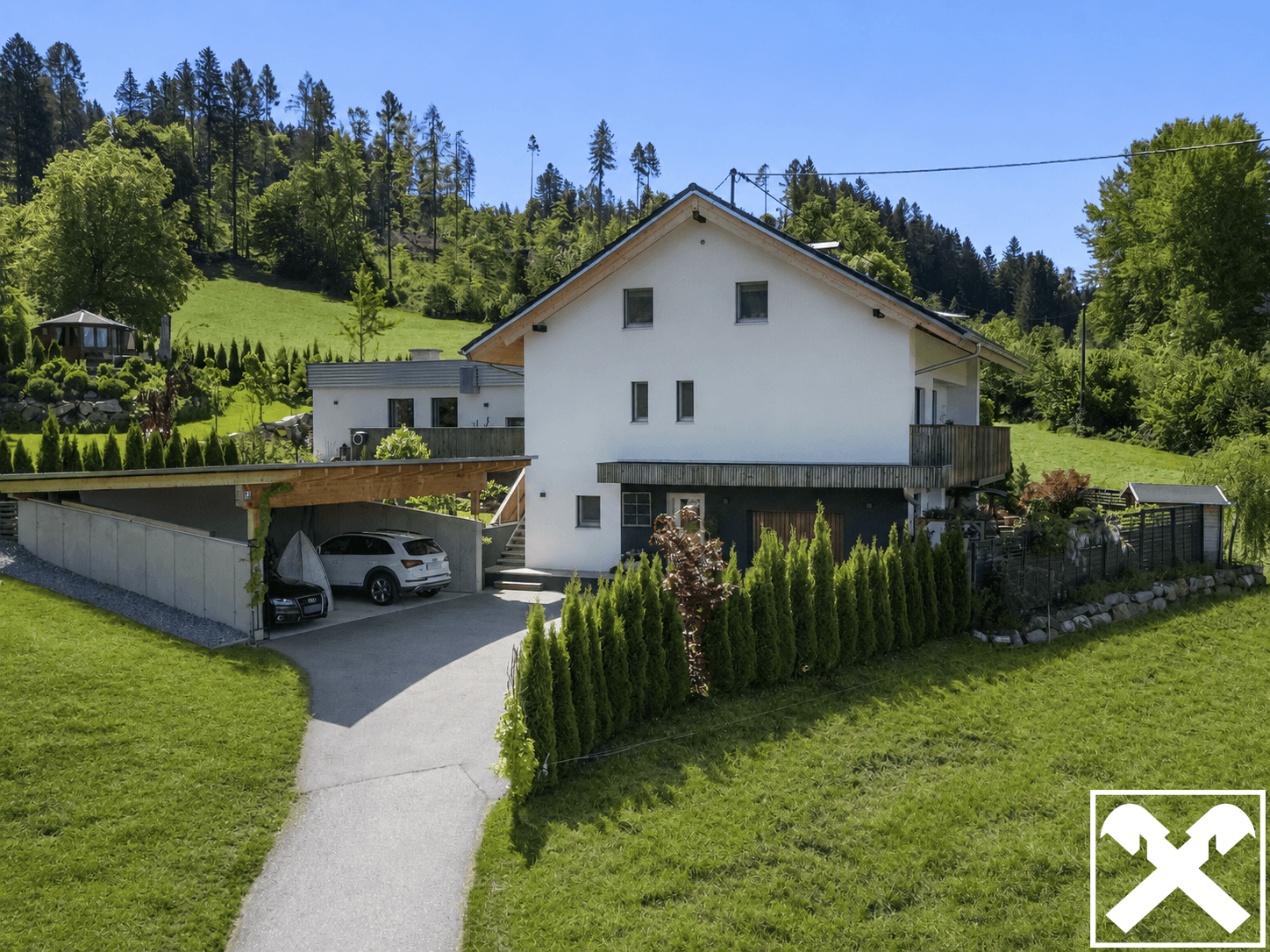 Modernes Einfamilienhaus mit Carport und gepflegtem Garten in ländlicher Umgebung.