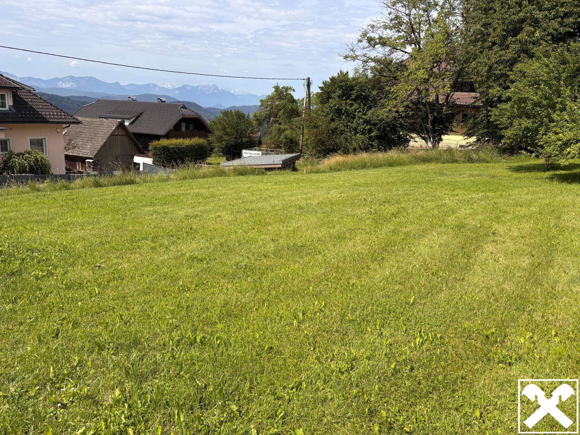 Große, gepflegte Rasenfläche mit Blick auf die umliegende Landschaft und entfernte Berge.