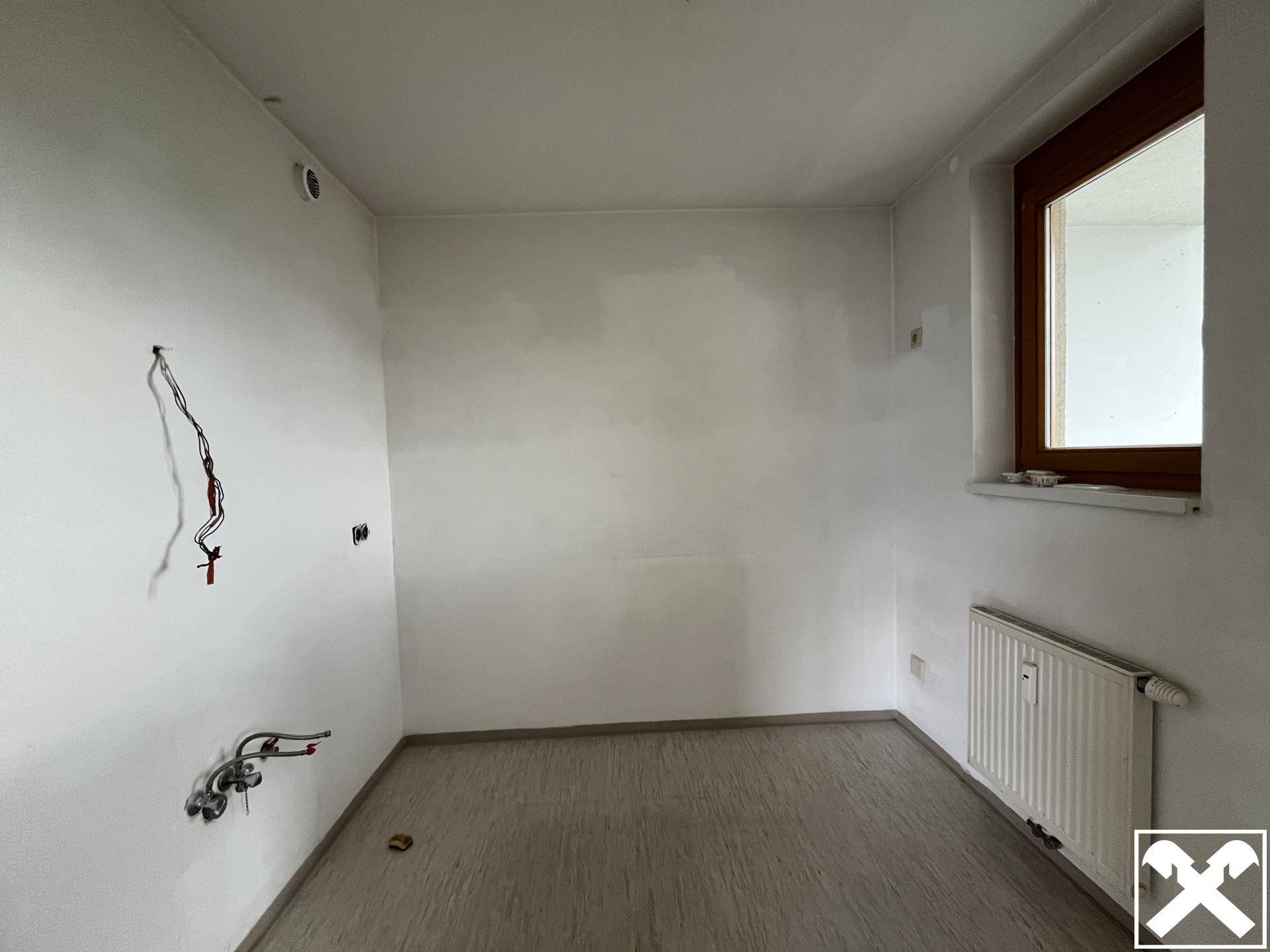 Raum vorbereitet für eine Küche mit Fenster und Heizkörper.