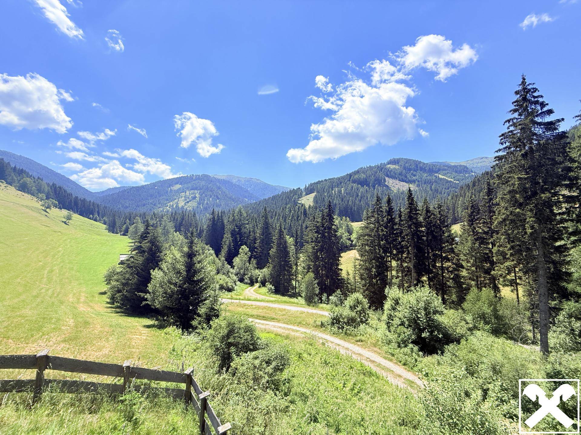 Malerischer Panoramablick auf die weite, grüne Berglandschaft unter blauem Himmel mit Wolken.