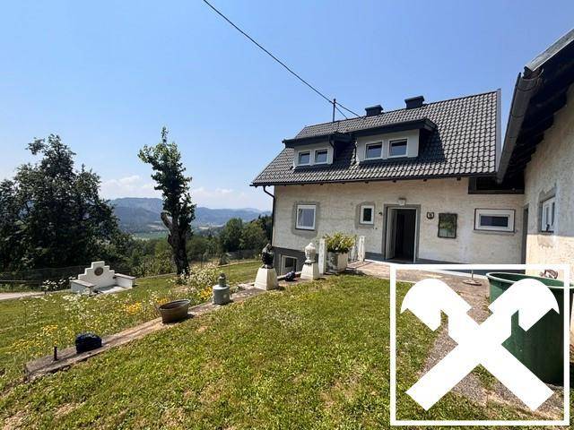 Hausfassade mit Terrasse und weitem Blick über die hügelige Landschaft und Berge.