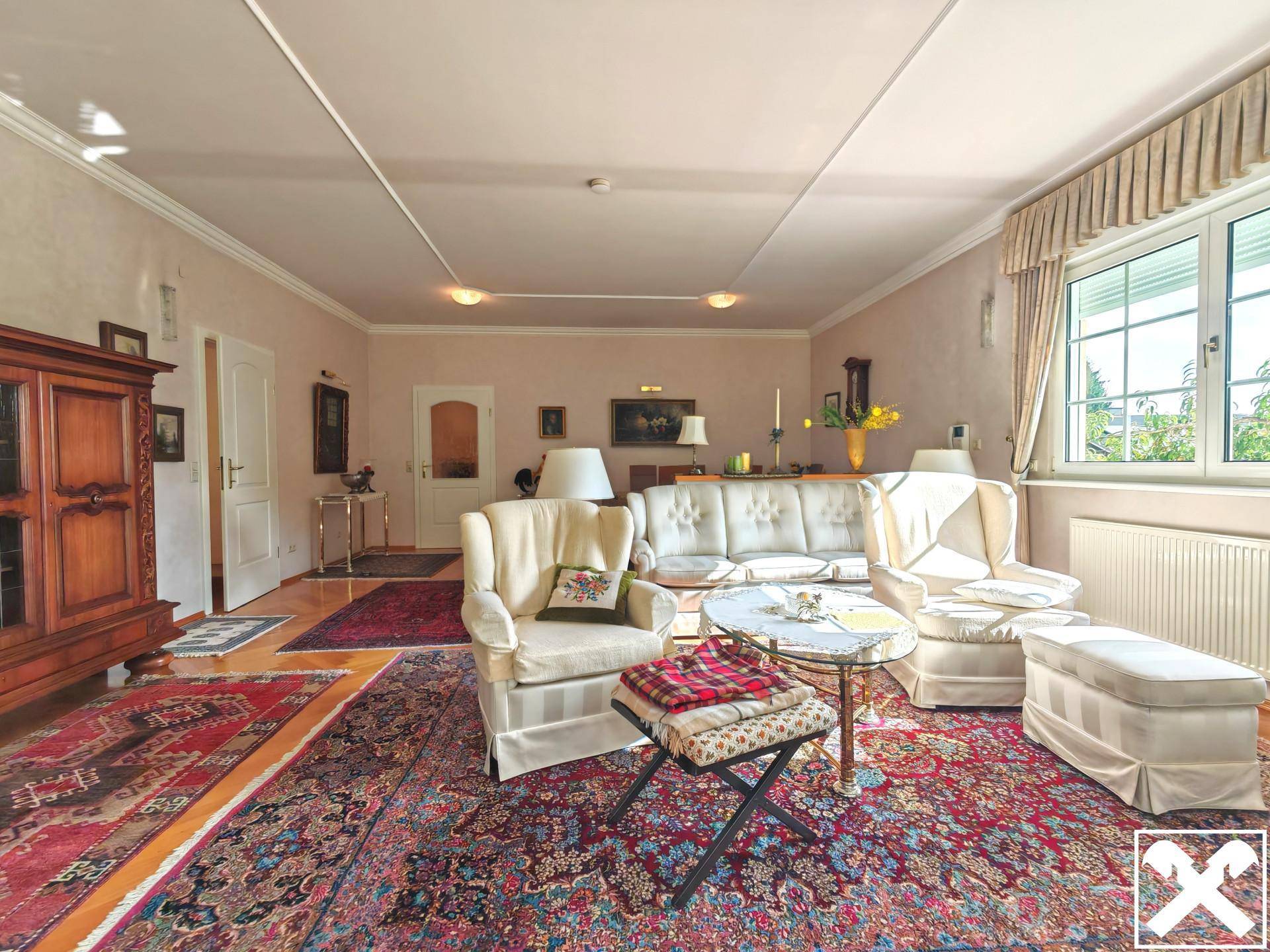 Gemütliches Wohnzimmer mit Parkettboden, bequemen Sofas und traditioneller Dekoration.