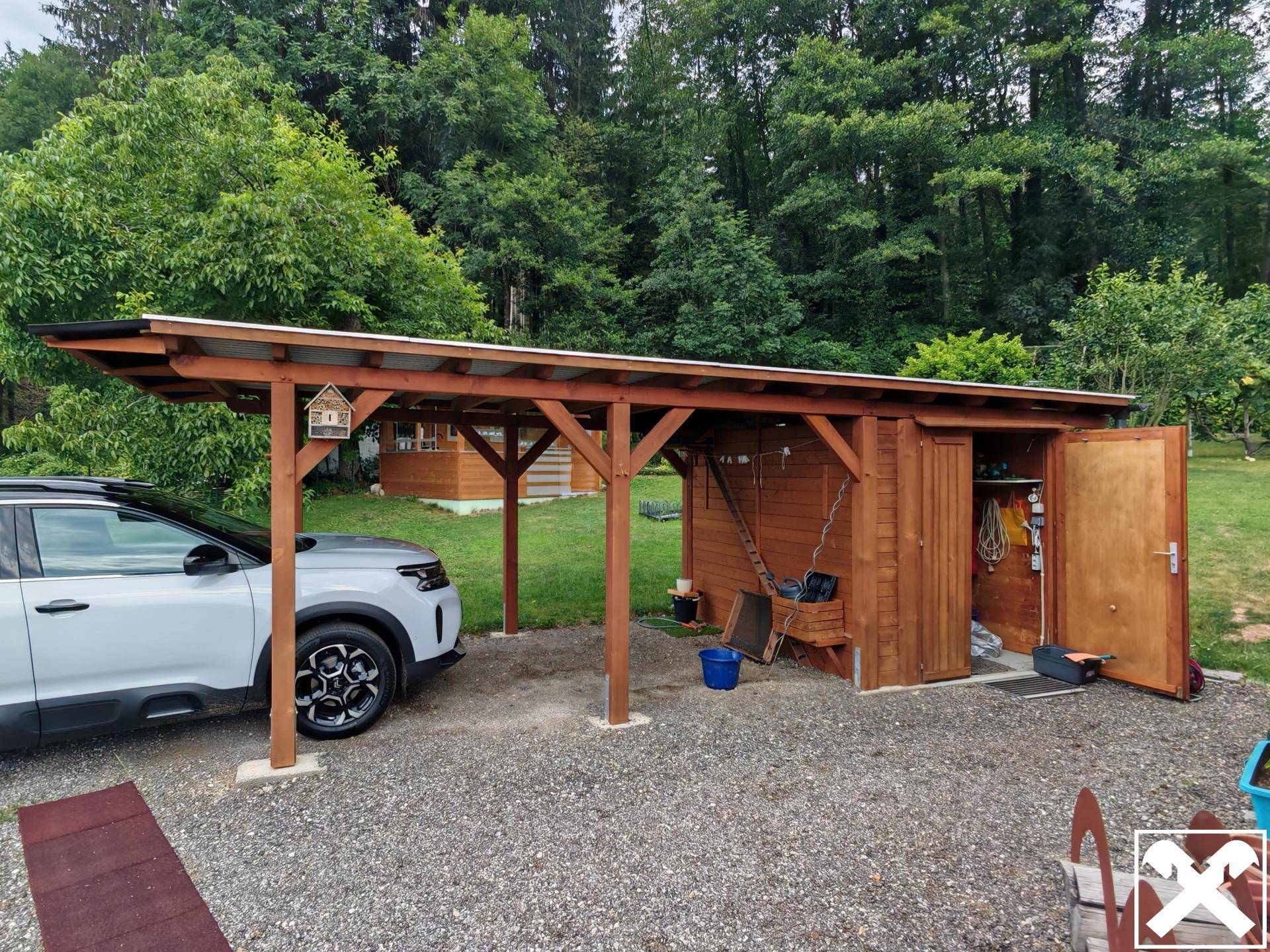 Robuster Holz-Carport mit integriertem Geräteschuppen und Stellplatz für ein Fahrzeug.