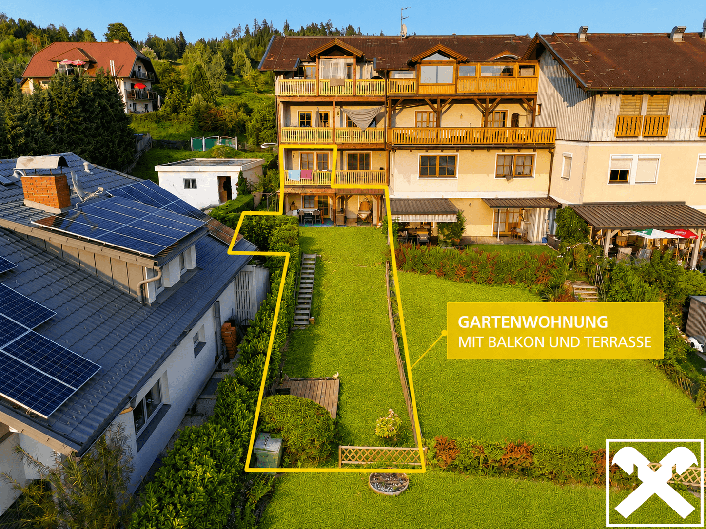 Gartenwohnung mit großem Rasenbereich, Balkon und Terrasse, umgeben von viel Grün.