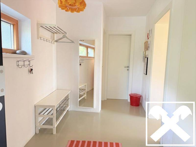 Heller Eingangsbereich mit Garderobe, Spiegel und praktischer Schuhbank.
