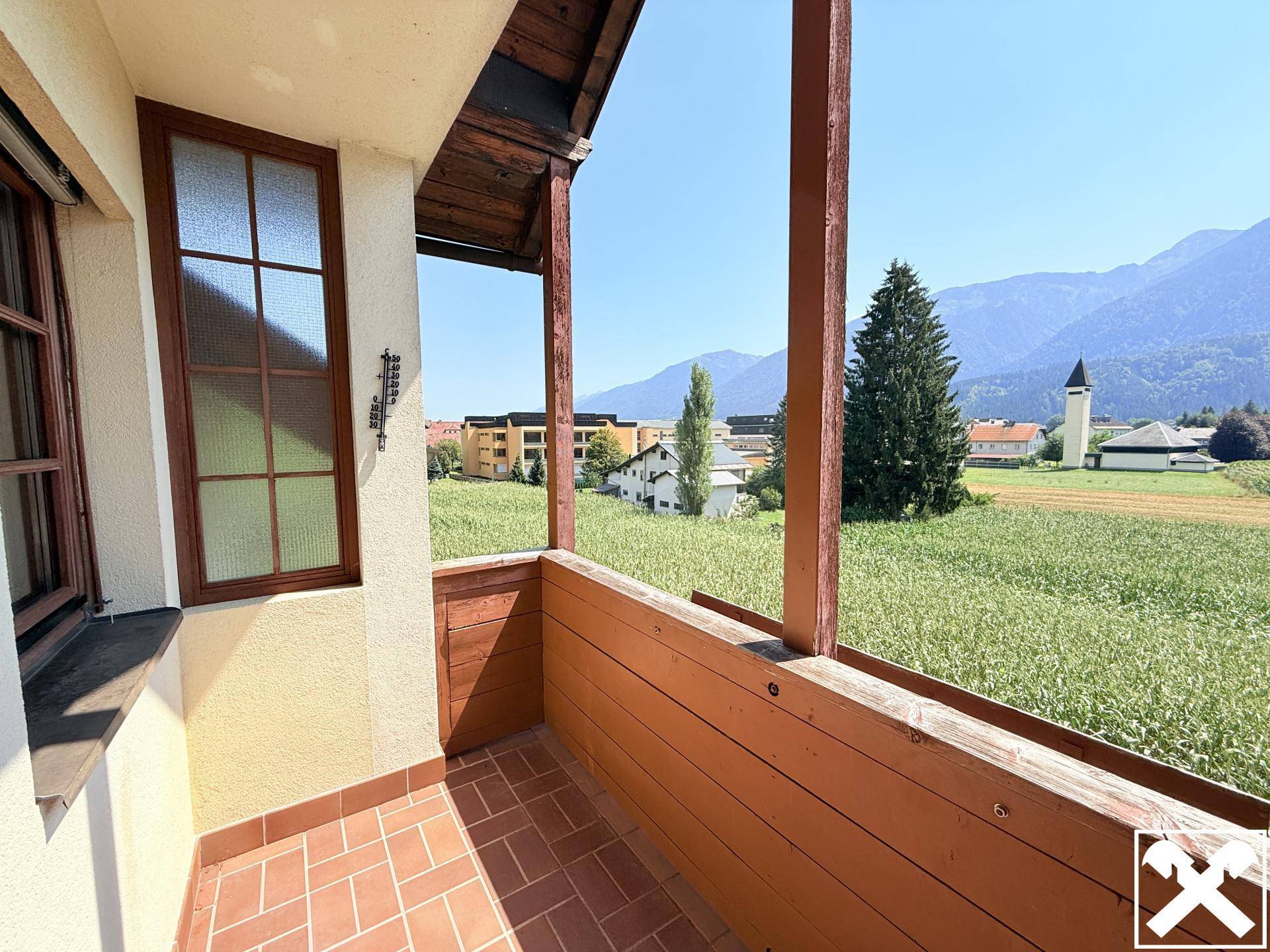 Gemütlicher Balkon mit Terrakotta-Fliesen und Holzelementen bietet einen weiten Bergblick.
