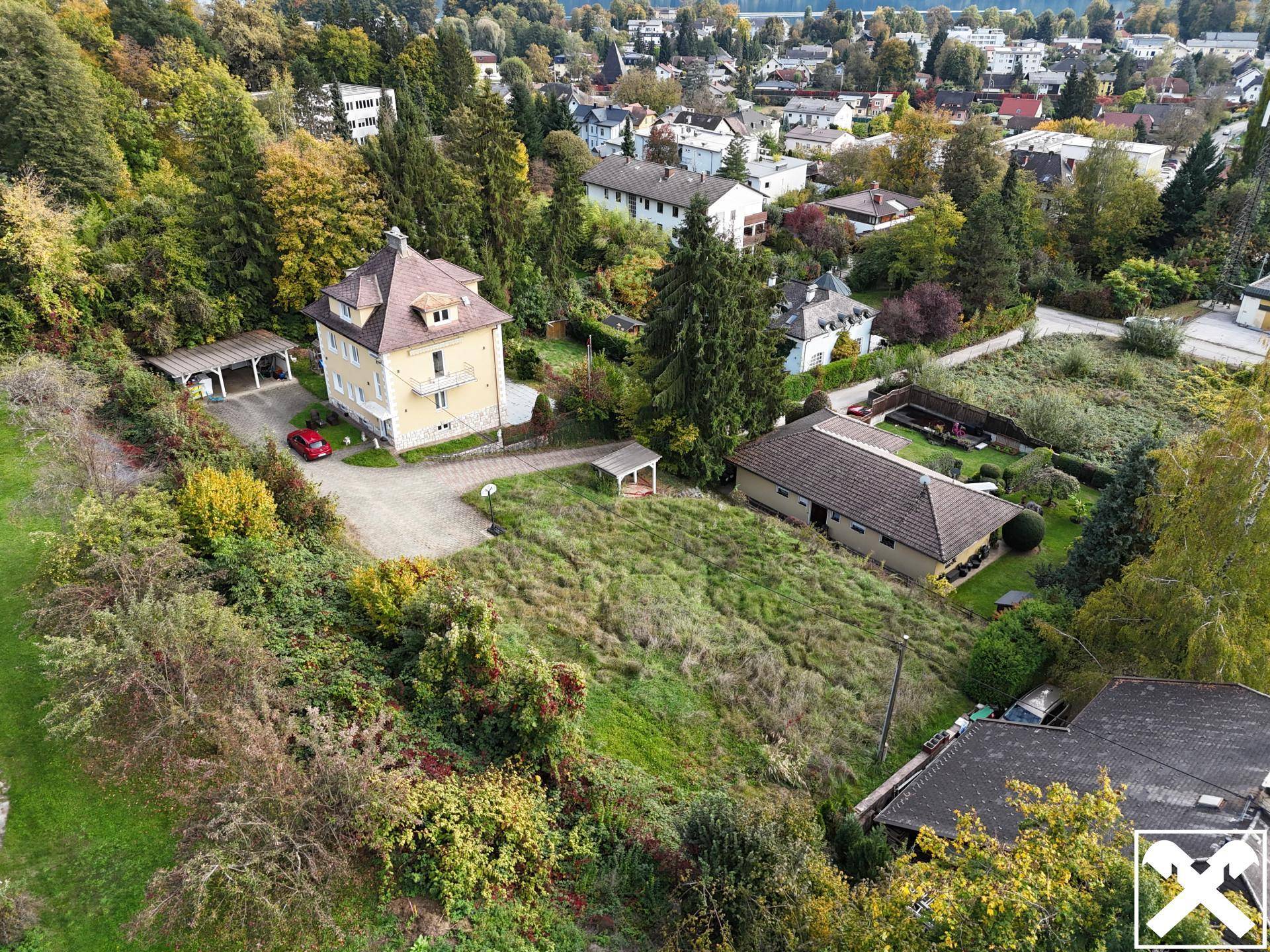 Panoramablick auf das Anwesen mit umliegender Natur und einem kleinen See in der Ferne.