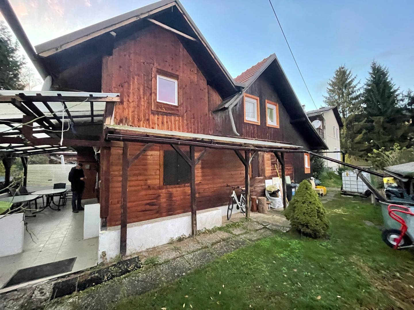 Rustikales Holzhaus mit überdachtem Eingangsbereich und Garten.