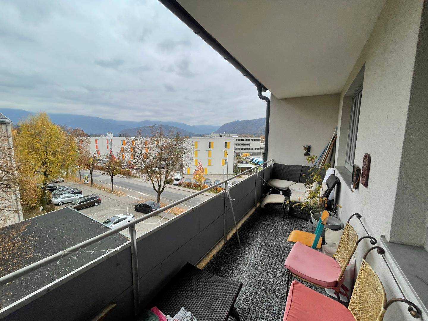 Geräumiger Balkon mit Sitzgelegenheiten und weitem Blick auf die umliegende Stadt und Berge.