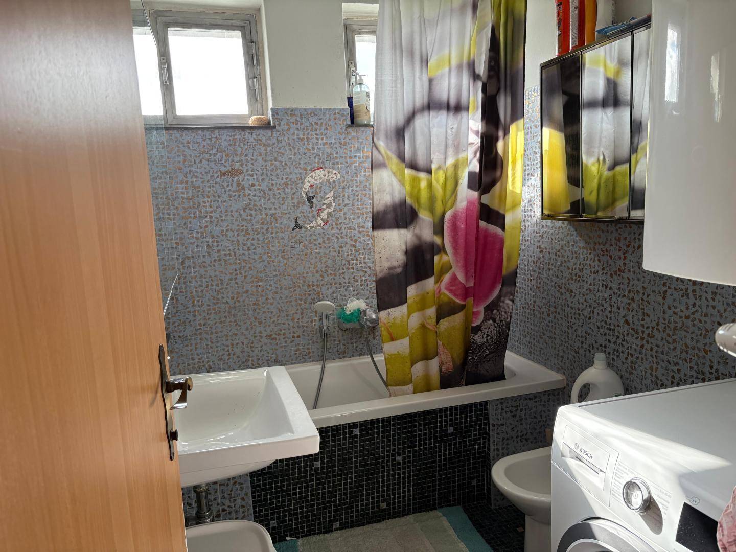 Badezimmer mit Badewanne, Waschbecken, Bidet und Waschmaschine.
