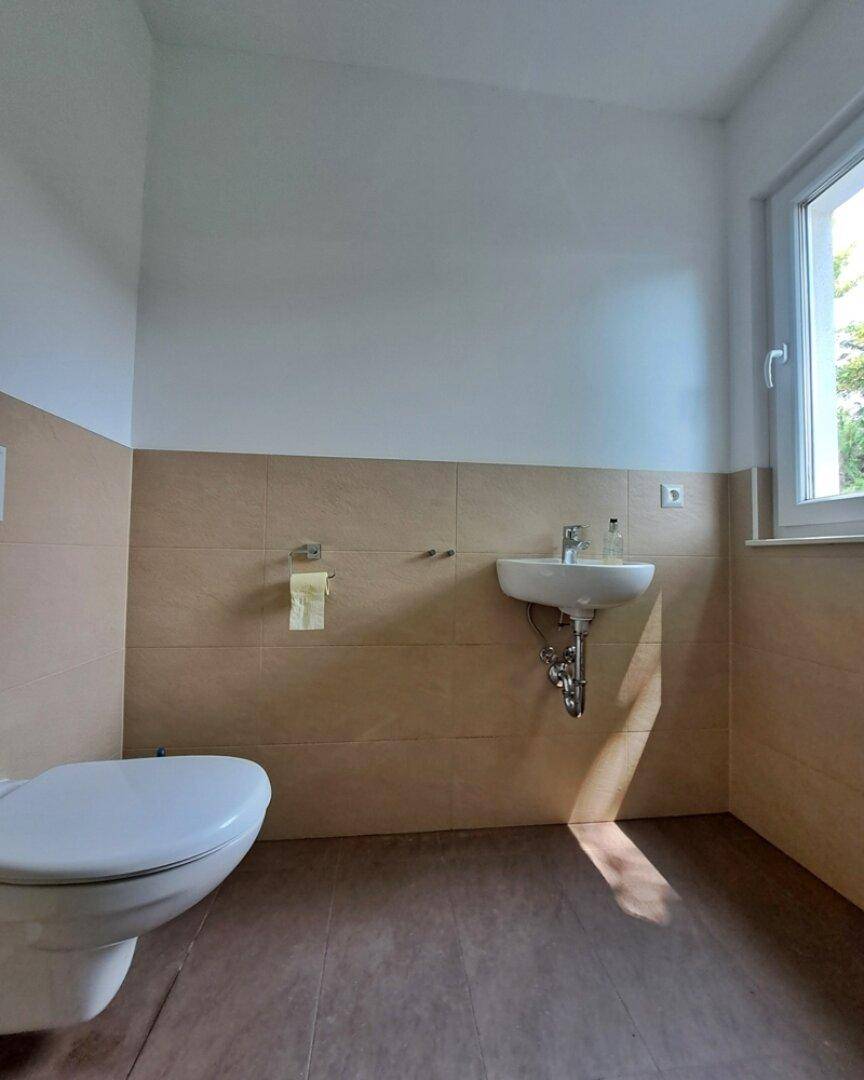 WC mit Waschtisch und Fenster im EG