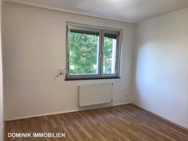 Helles Zimmer mit Blick ins Grüne und Laminatboden, ideal als Schlaf- oder Arbeitszimmer.