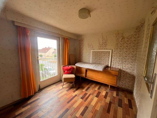 Schlafzimmer mit Holzboden, gemusterter Tapete und Zugang zu einem französischen Balkon.