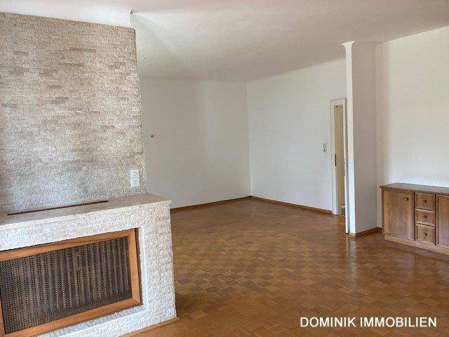 Heller Wohnbereich mit Parkettboden und einem dekorativen Kamin als Raumteiler.